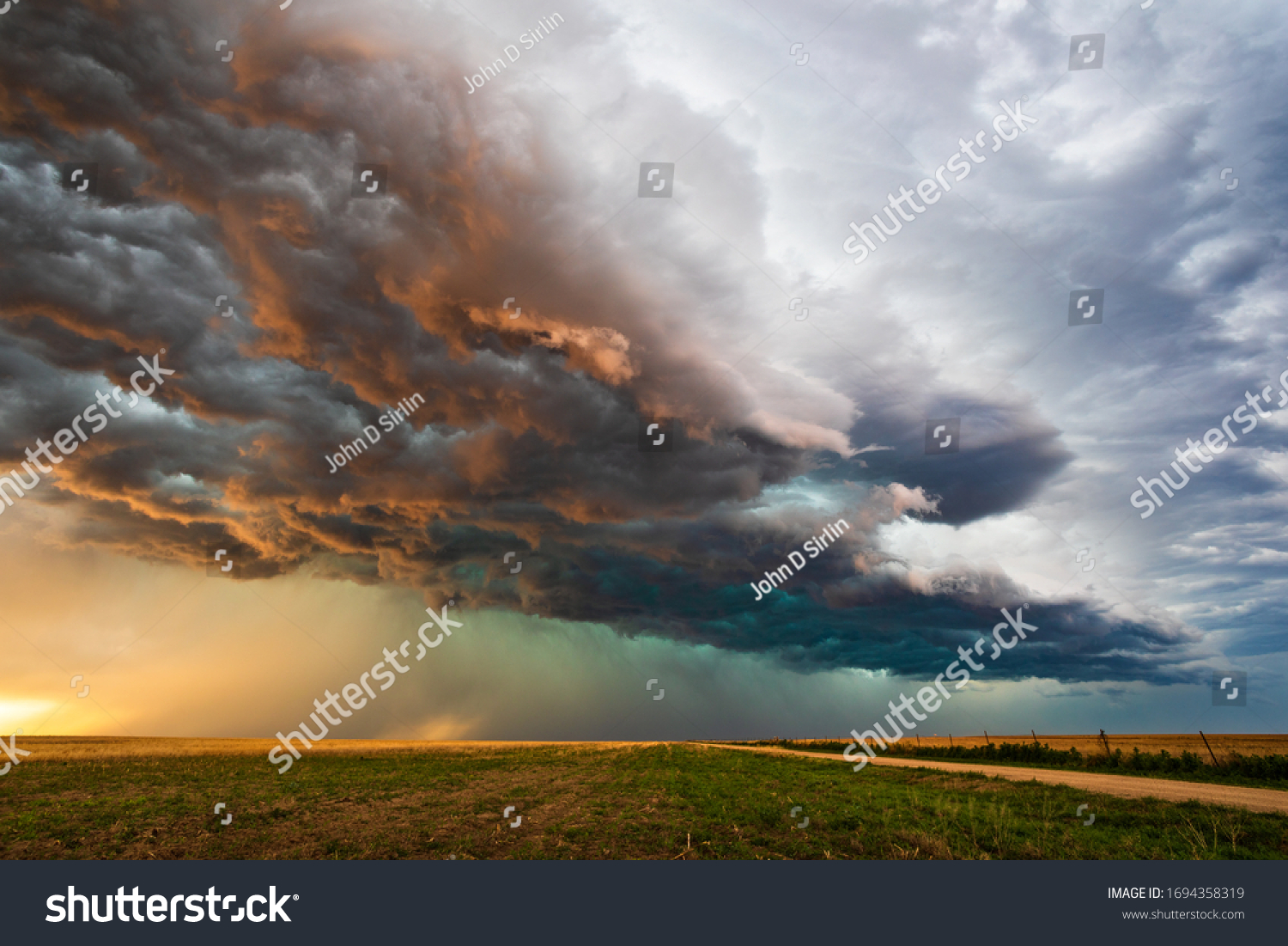Stormy sky with dramatic clouds from an approaching thunderstorm at sunset #1694358319