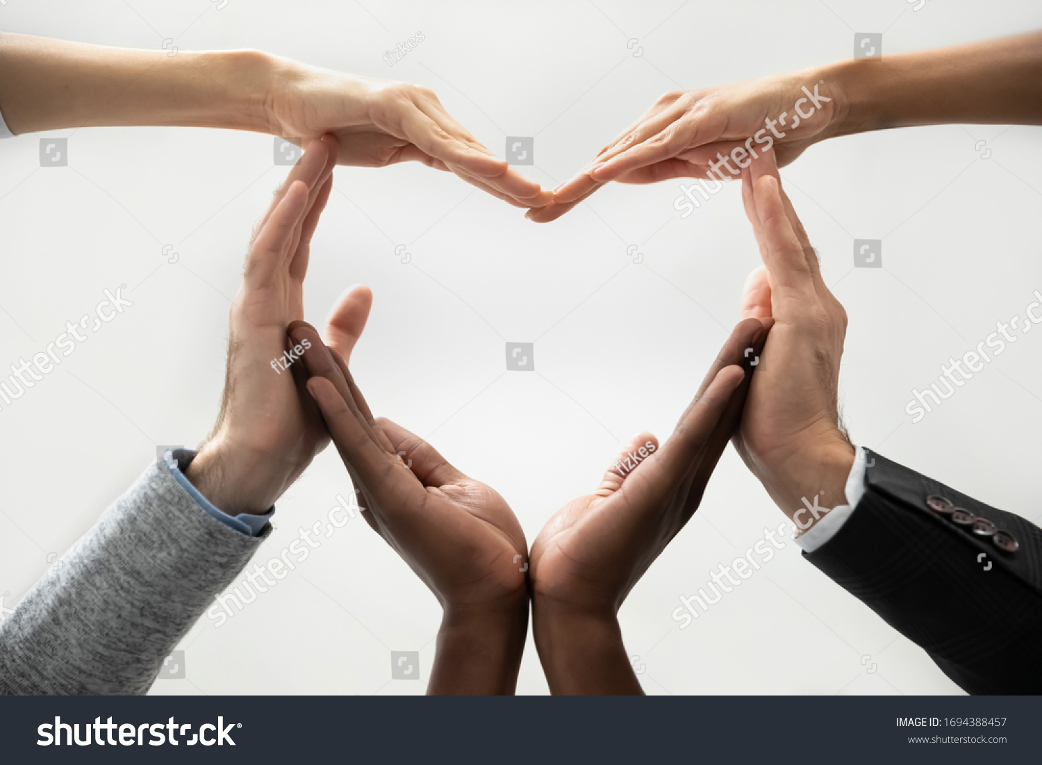 Close up bottom view concept of diverse business people join hands forming heart. Show unity and support, protection of business. Multiracial colleagues involved in team building activity for charity. #1694388457