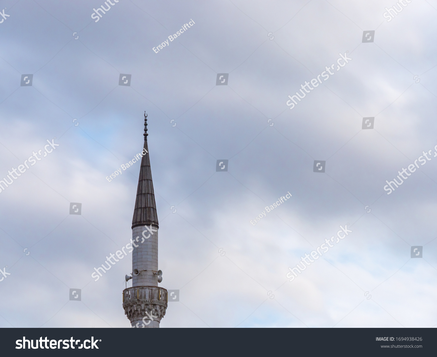 Minaret of a Muslim mosque on the background of the cloudy sky. minaret aspiring to heaven. #1694938426