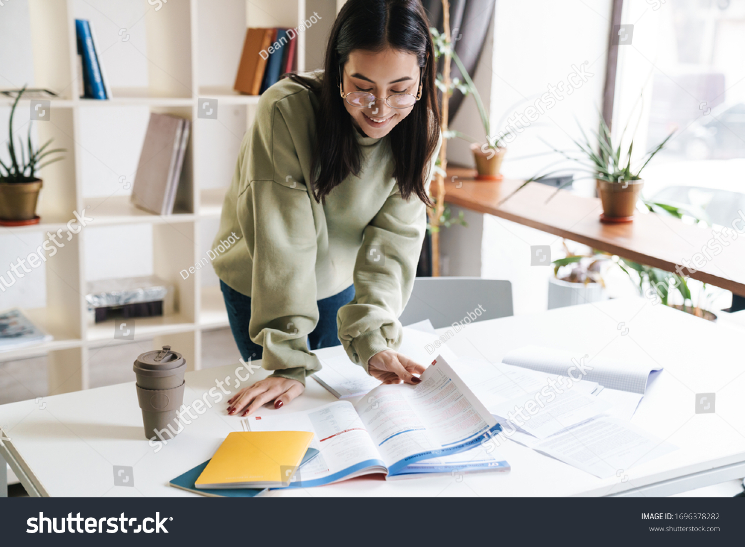 Image of a pretty happy smiling young girl student indoors studying. #1696378282