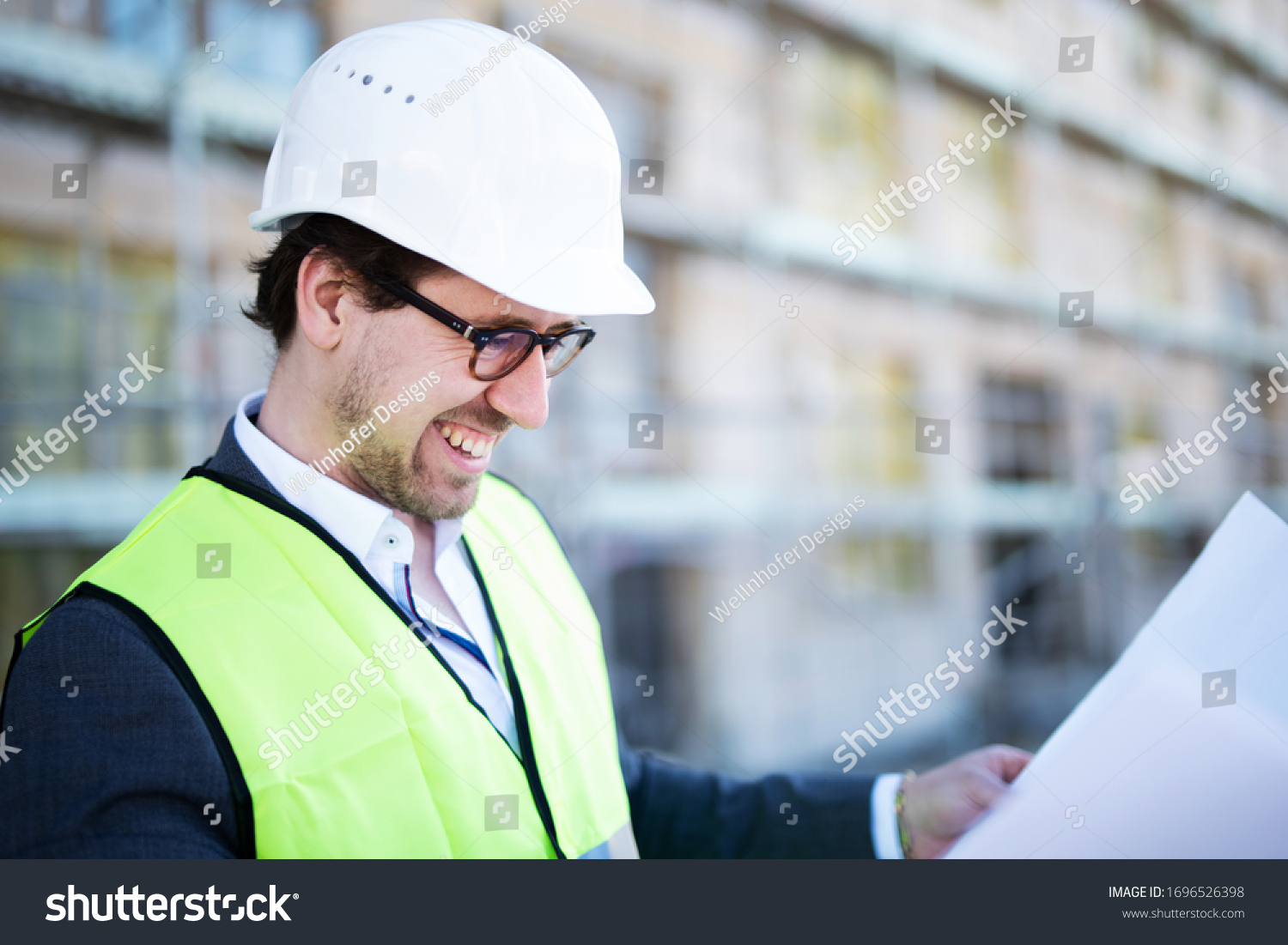 
Happy smiling architect on a construction site with blueprints #1696526398
