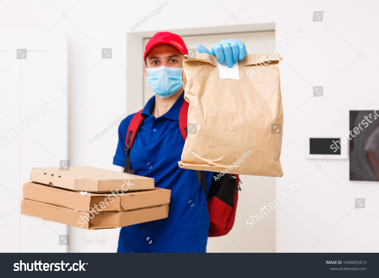 Delivery man employee in red cap t-shirt uniform mask gloves give food order pizza boxes isolated on yellow background studio. Service quarantine pandemic coronavirus virus flu 2019-ncov concept #1696859413