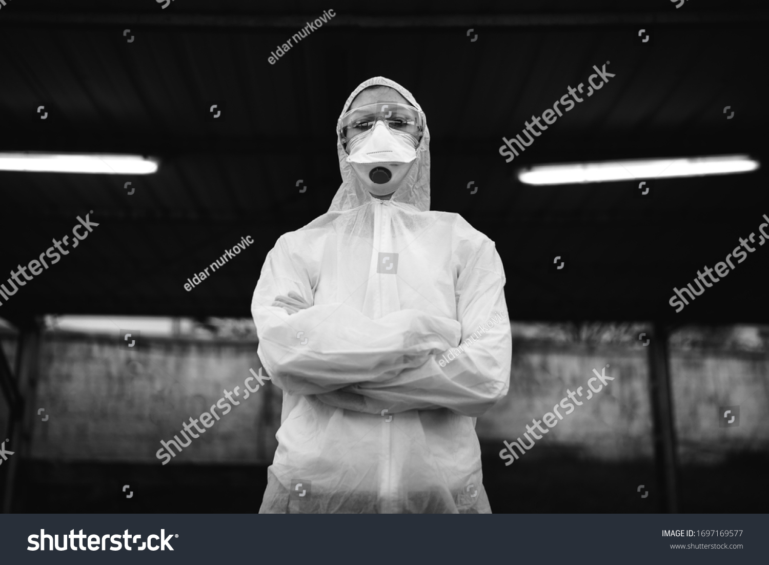 COVID-19 coronavirus doctor in hazmat suit.Infectious disease pandemic medical worker.Female physician in uniform on frontline,fighting viral outbreak.Protective suit with N95 mask. #1697169577