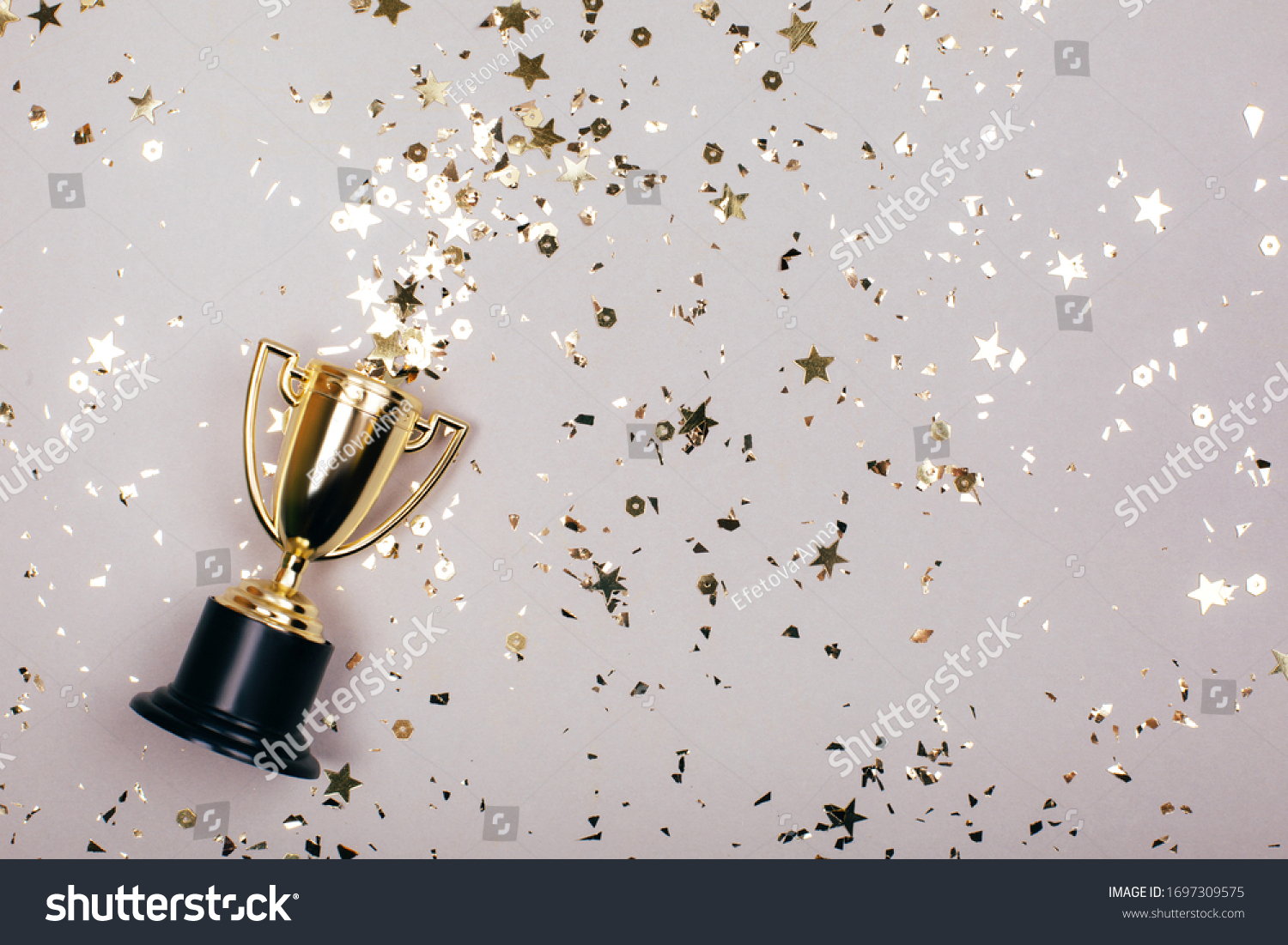 Sparkles grey background with a winners cup. Flat lay style. #1697309575