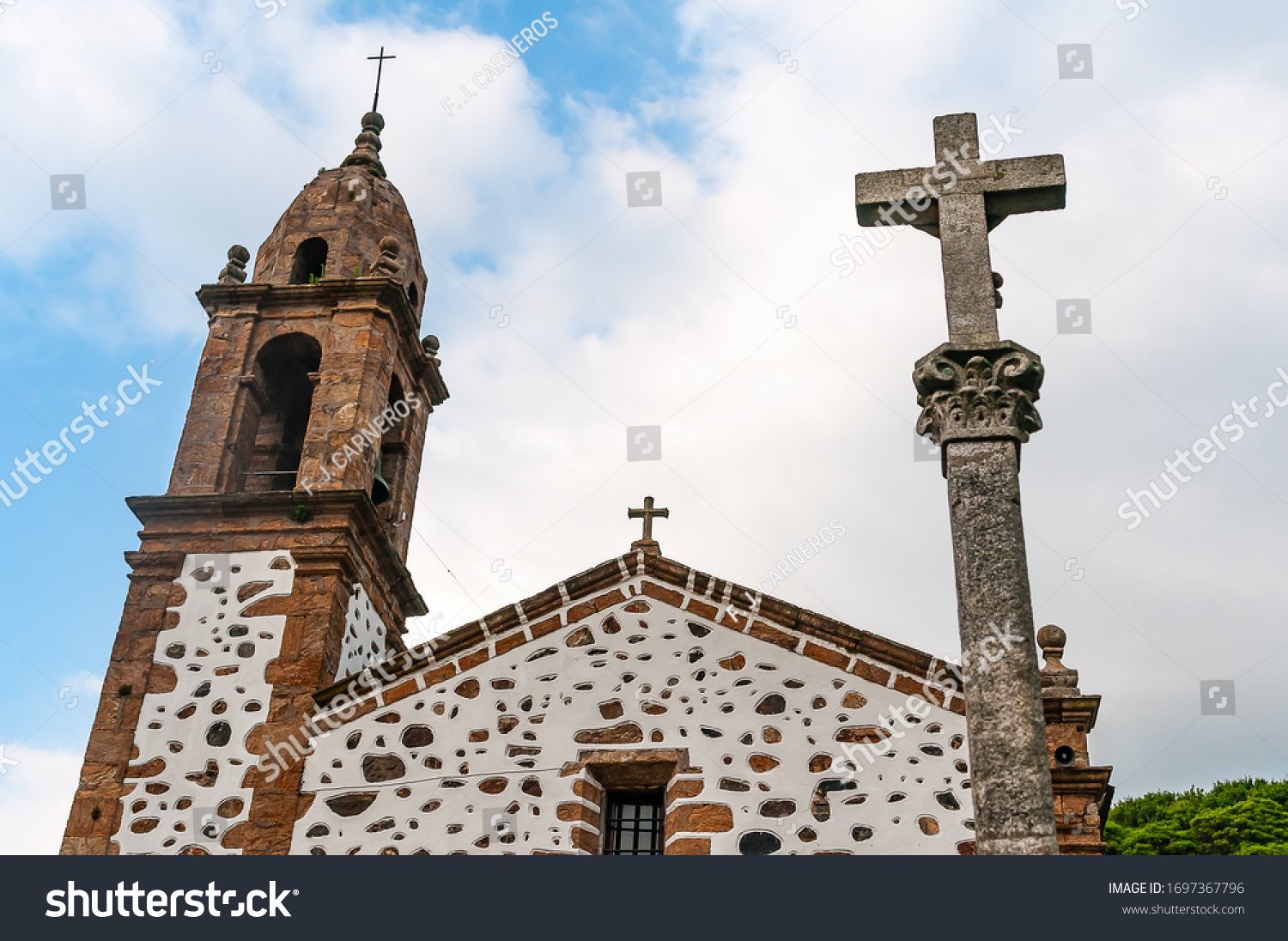 SAN ANDRES DE TEIXIDO, LA CORUÑA, GALICIA, SPAIN - JULY 5, 2019: Church and stone cross #1697367796