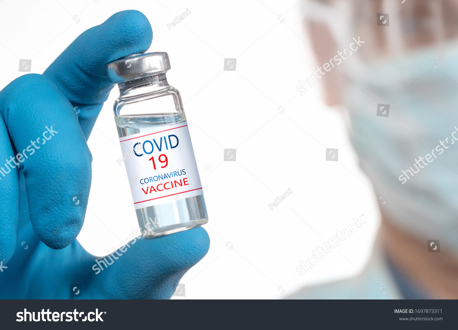 Development and creation of a coronavirus vaccine COVID-19 .Coronavirus Vaccine in glass bottle in hand of doctor blue vaccine jar on white background. Vaccine Concept of fight against coronavirus #1697873311