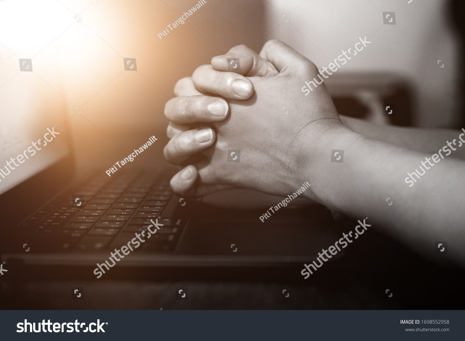 Hand praying with laptop, Church online Sunday services concept, Home church during quarantine coronavirus Covid-19, Hands folded in prayer concept for faith.