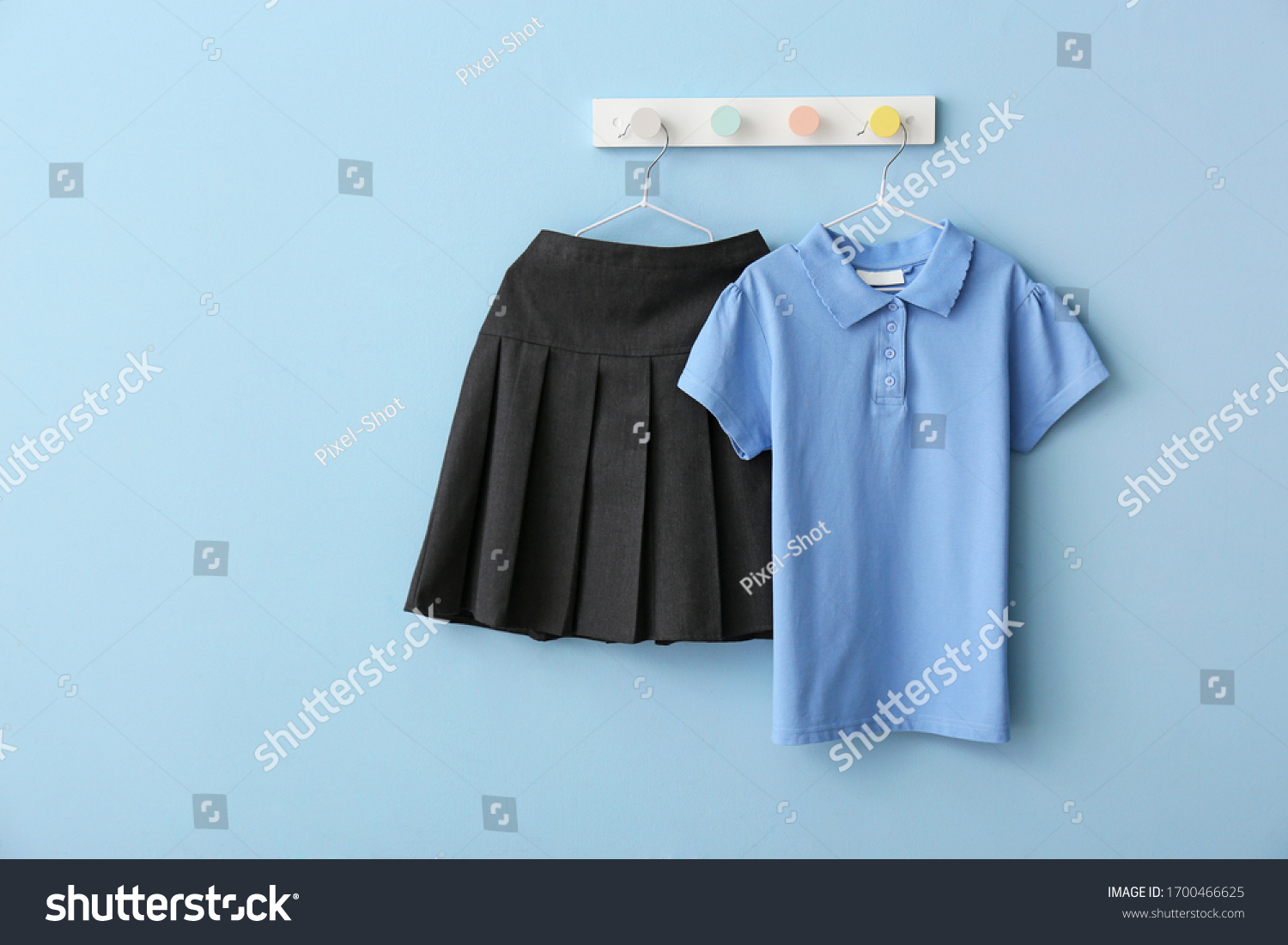 Stylish school uniform hanging on color wall #1700466625