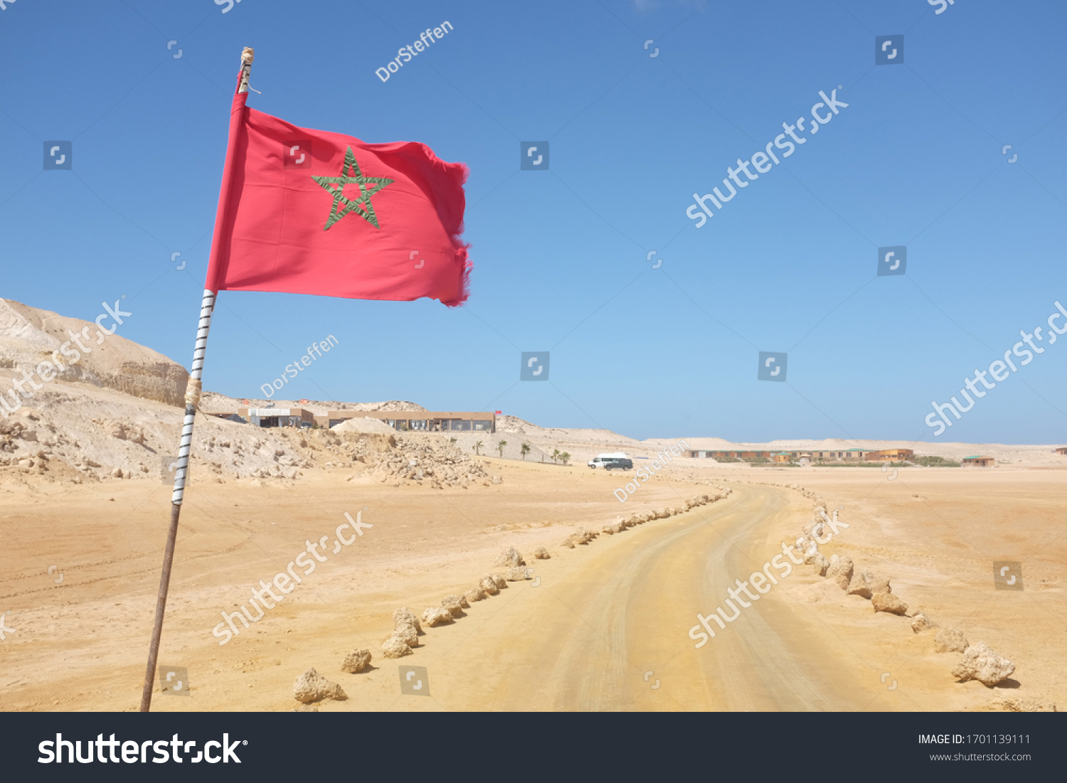 Desert Road with Moroccan Flag in Western Sahara Leading to Tourist Resort #1701139111