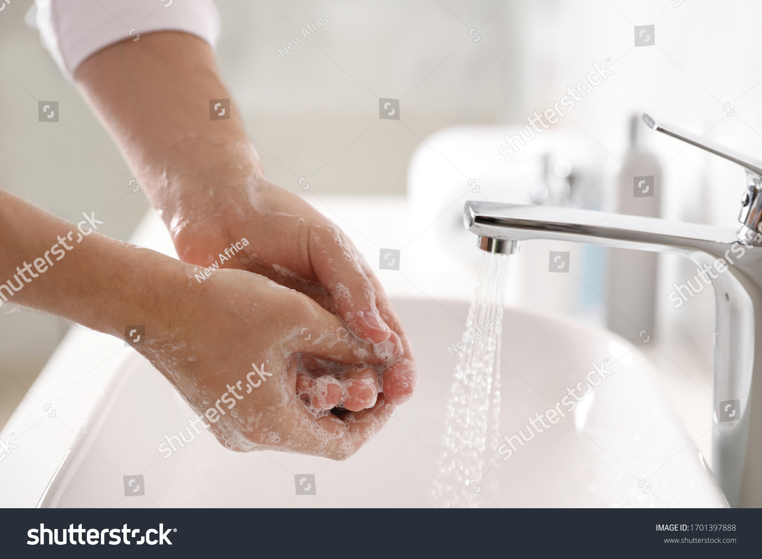 Man washing hands with soap over sink in bathroom, closeup #1701397888