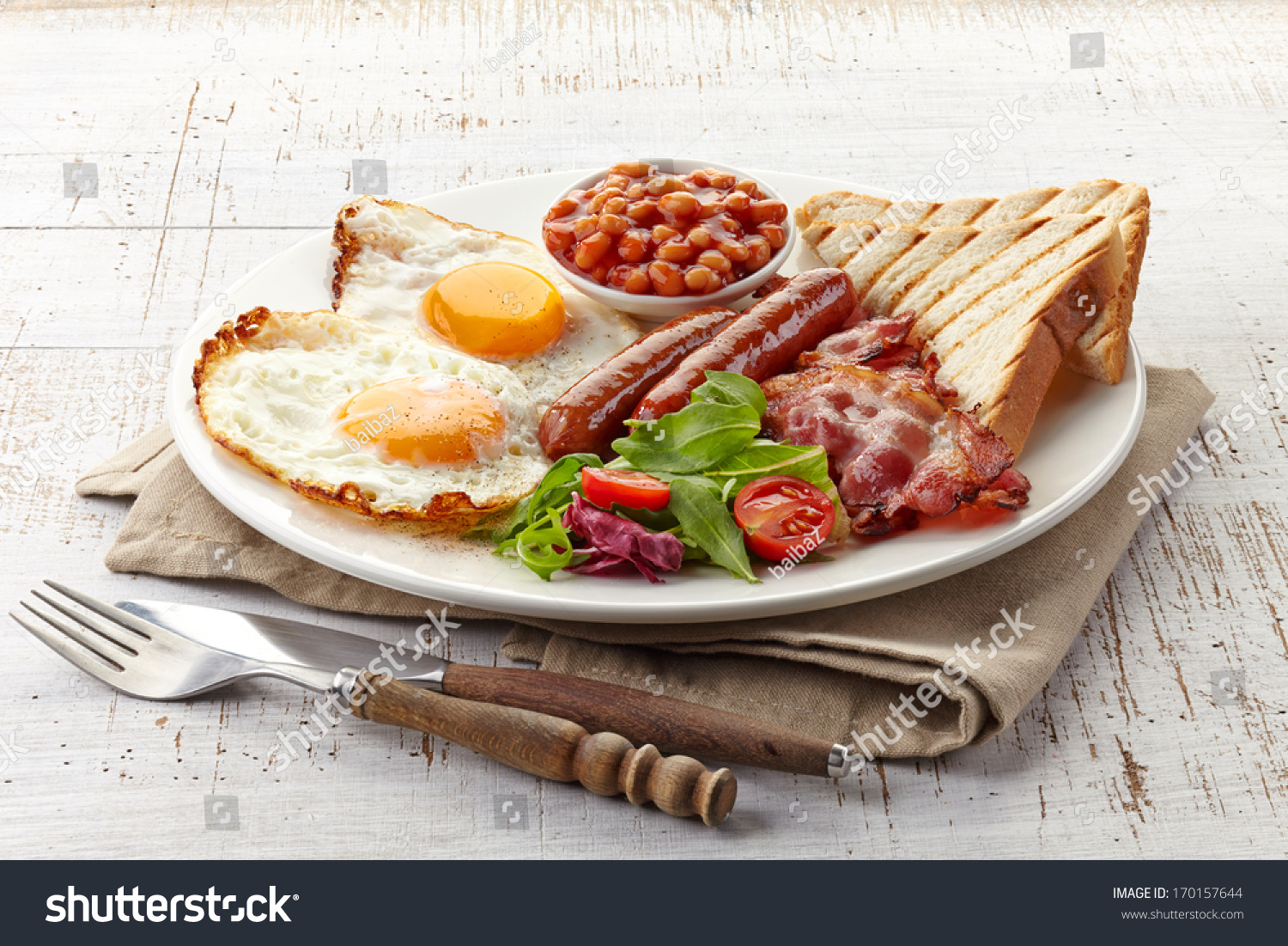 English breakfast with fried eggs, bacon, sausages, beans, toasts and fresh salad #170157644
