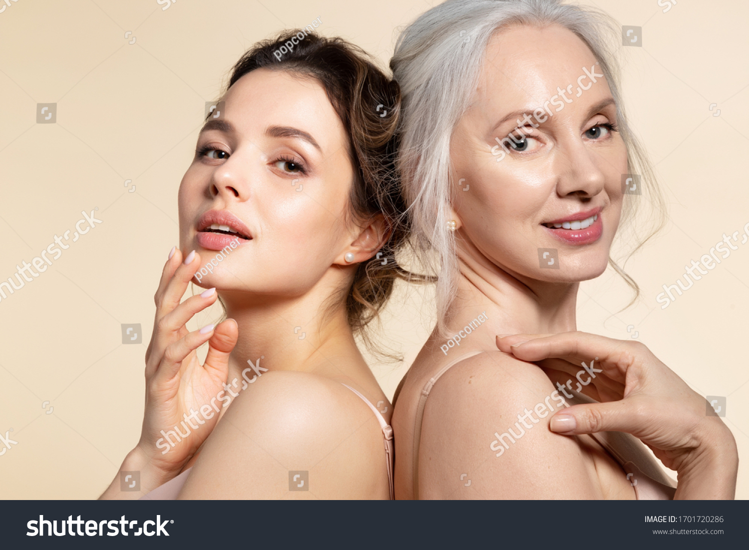 Two beautiful different age woman with perfect skin headshot portrait. Senior lady and young girl in underwear standing back-to-back posing for camera. Spa beauty salon procedure and home skincare #1701720286