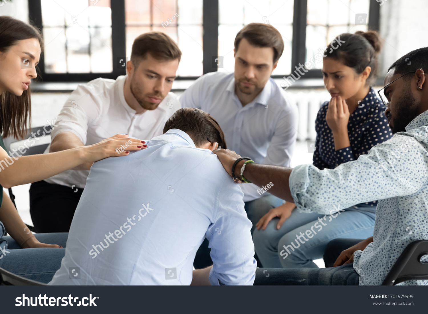 Multiethnic young people sit in circle participate in group psychological therapy together, diverse patients hug support comfort upset man patient at team counseling session, depression concept #1701979999