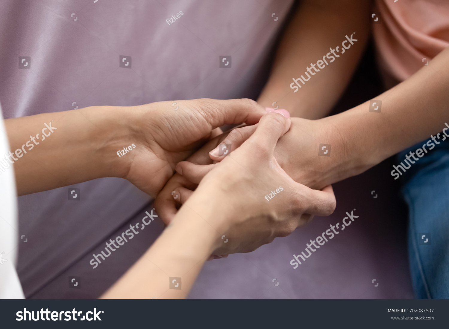 Close up african american mother and teen daughter hand holding together. Caring family spend time in private in living room at home. Young mom and girl create sweet bonding. #1702087507