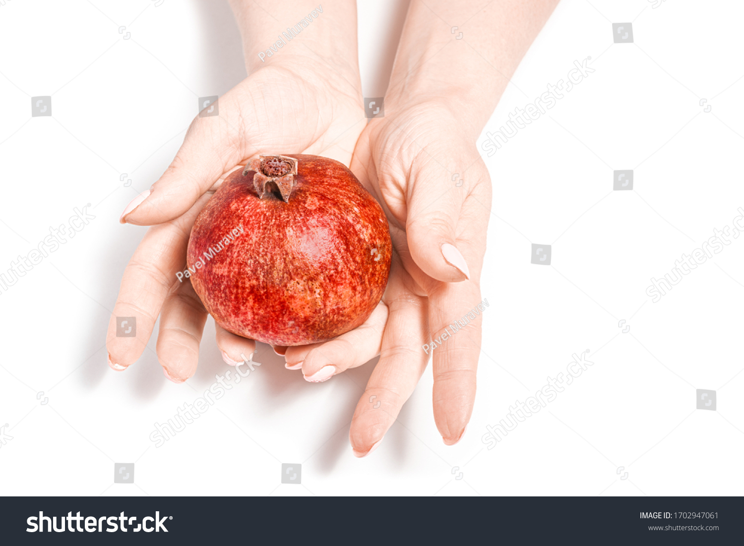 bright pomegranate in the hands of a girl on a white background. Woman holds ripe pomegranate fruit. Concept: fruit diet, isolated #1702947061