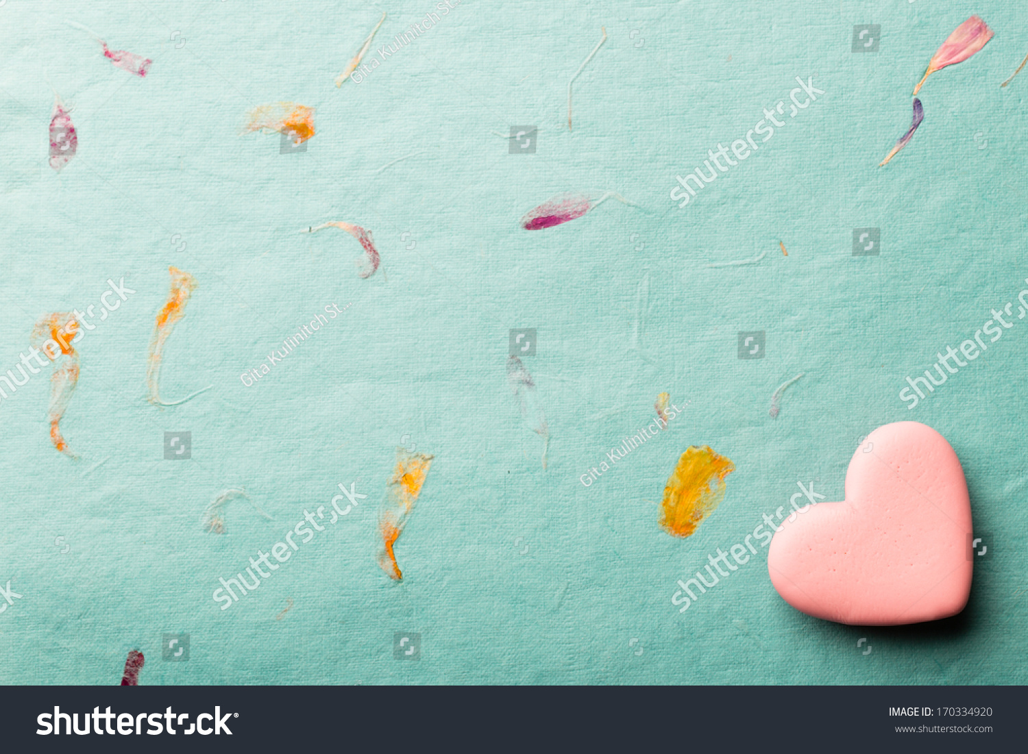 Pink heart-shaped candy on a paper background. #170334920