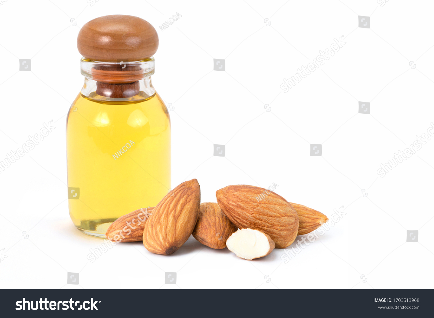 Closeup almond oil in glass bottle and group of almond nuts with slice isolated on white background.  #1703513968