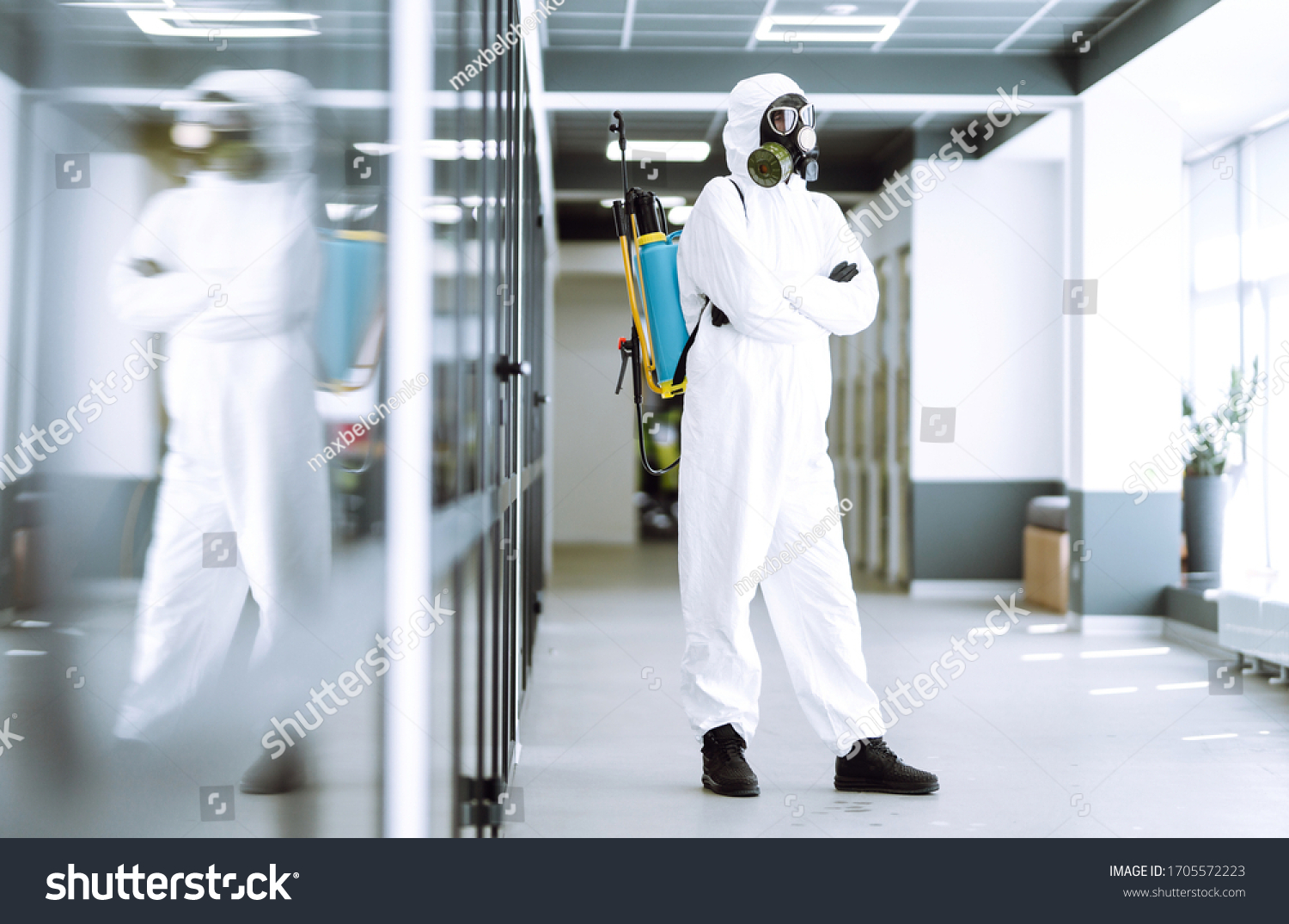 Man in protective hazmat suit in an empty office. Concepts to preventing the spread of coronavirus, pandemic in quarantine city. Covid -19. #1705572223
