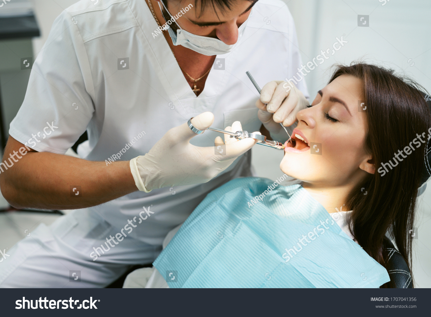 Painkiller anesthesia injection. Dentist examining a patient's teeth in modern dentistry office. Closeup cropped picture with copyspace. Doctor in disposable medical facial mask. #1707041356