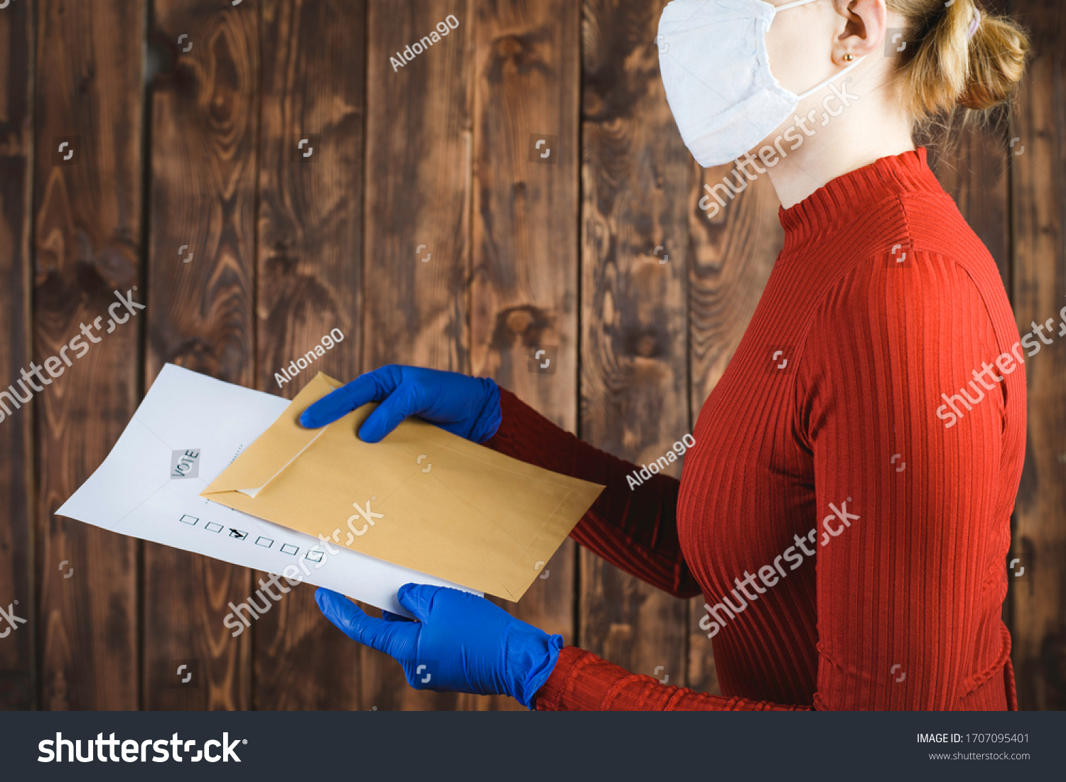 A person in blue protective gloves sends a letter with a correspondence voting card. Elections during the quarantine of the coronavirus epidemic.
 #1707095401