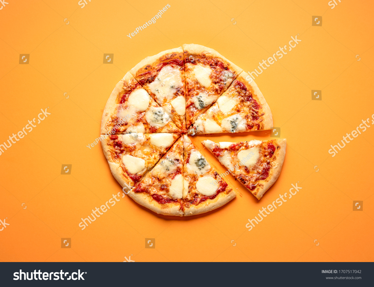 Sliced cheese pizza on an orange background above view. Pizza sliced in eight. Delicious homemade pizza top view. Pizza made only with cheese and tomato sauce. #1707517042