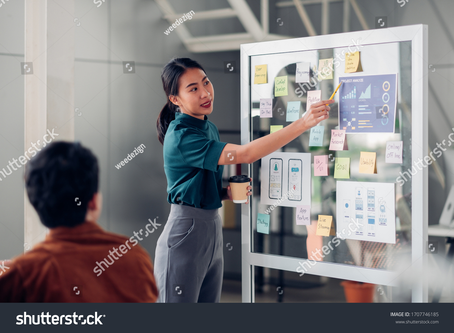 asian ux developer and ui designer presenting mobile app interface design on whiteboard in meeting at modern office.Creative digital development mobile app agency.digital transformation #1707746185