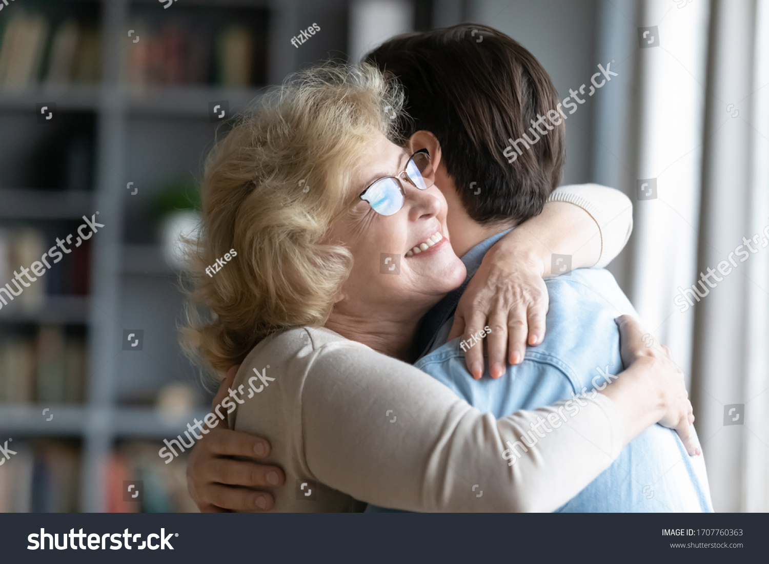 Loving elderly mother in glasses closed eyes enjoy moment strong cuddles adult son after long separation, grandmother glad to see grandson multi generational family reunion, love and bonding concept #1707760363