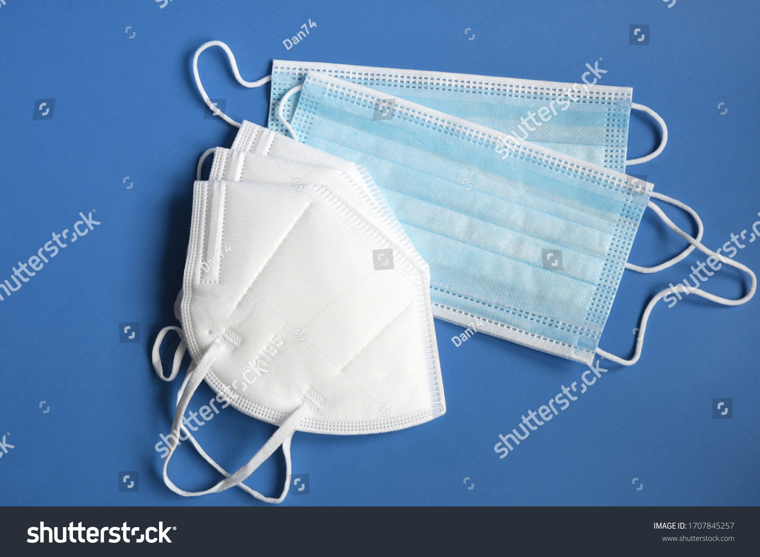 white KN95 or N95 mask with antiviral medical mask for protection against coronavirus on blue background. Surgical protective mask. prevention of the spread of virus and pandemic COVID-19. #1707845257