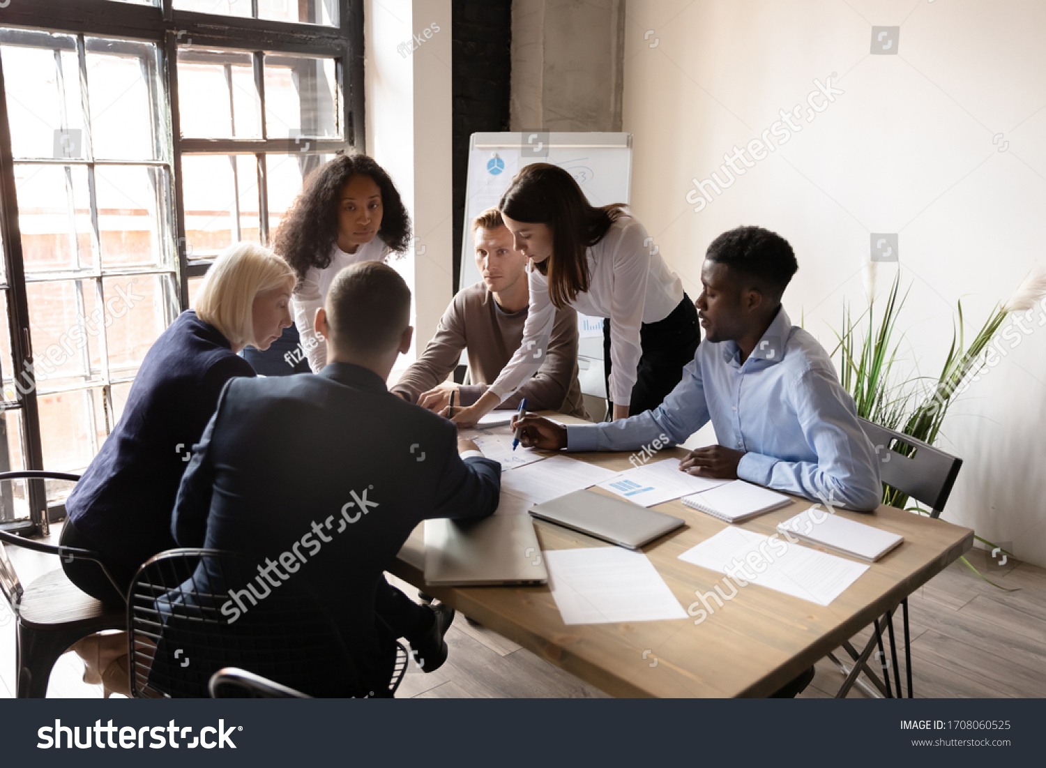 Top view of multicultural colleagues gather at desk in office brainstorm consider paperwork together, diverse employees discuss financial business project ideas at briefing, cooperation concept #1708060525