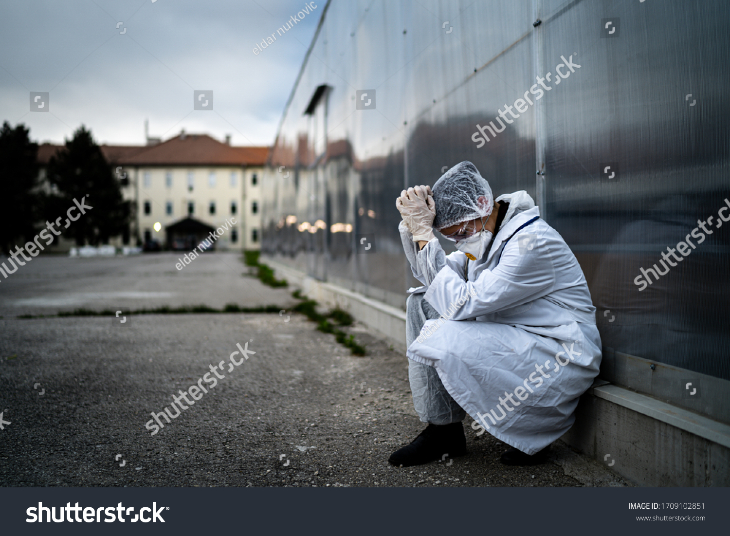 Frightened doctor for infectious diseases having mental nervous break down.Coronavirus COVID-19 exhausted physician in fear.Working in improvised medical facility isolation ward.Medical worker stress #1709102851