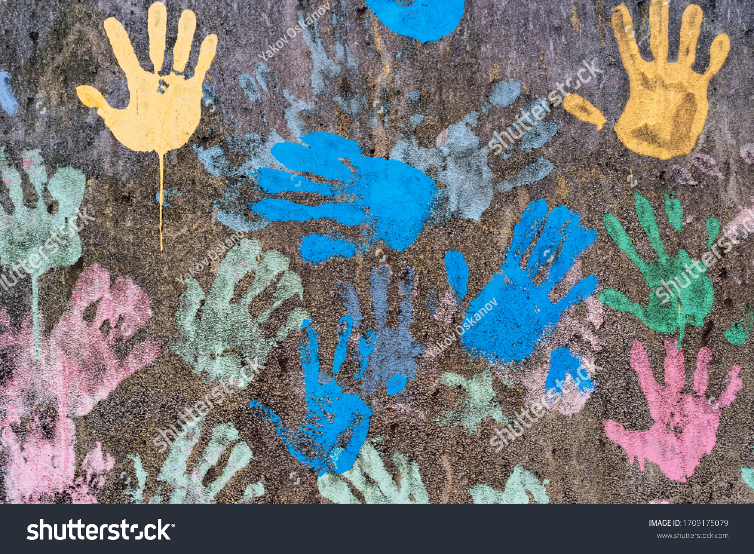 Dark background with colorful handprints symbolising interracial friendship #1709175079