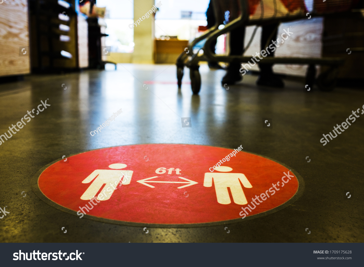 Red circle symbol sign printed on ground at US supermarket cash register cue informing people to keep 6 feet distance from each other to prevent spreading Coronavirus COVID-19 virus disease infection #1709175628