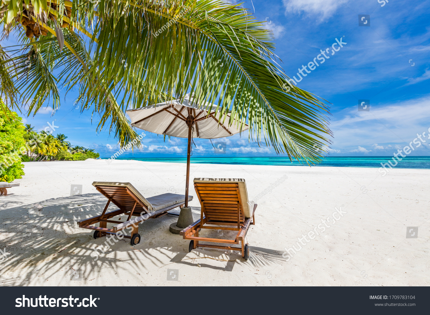 Tropical beach nature as summer landscape with lounge chairs and palm trees and calm sea for beach banner. Luxurious travel landscape, beautiful destination for vacation or holiday. Beach scene
 #1709783104