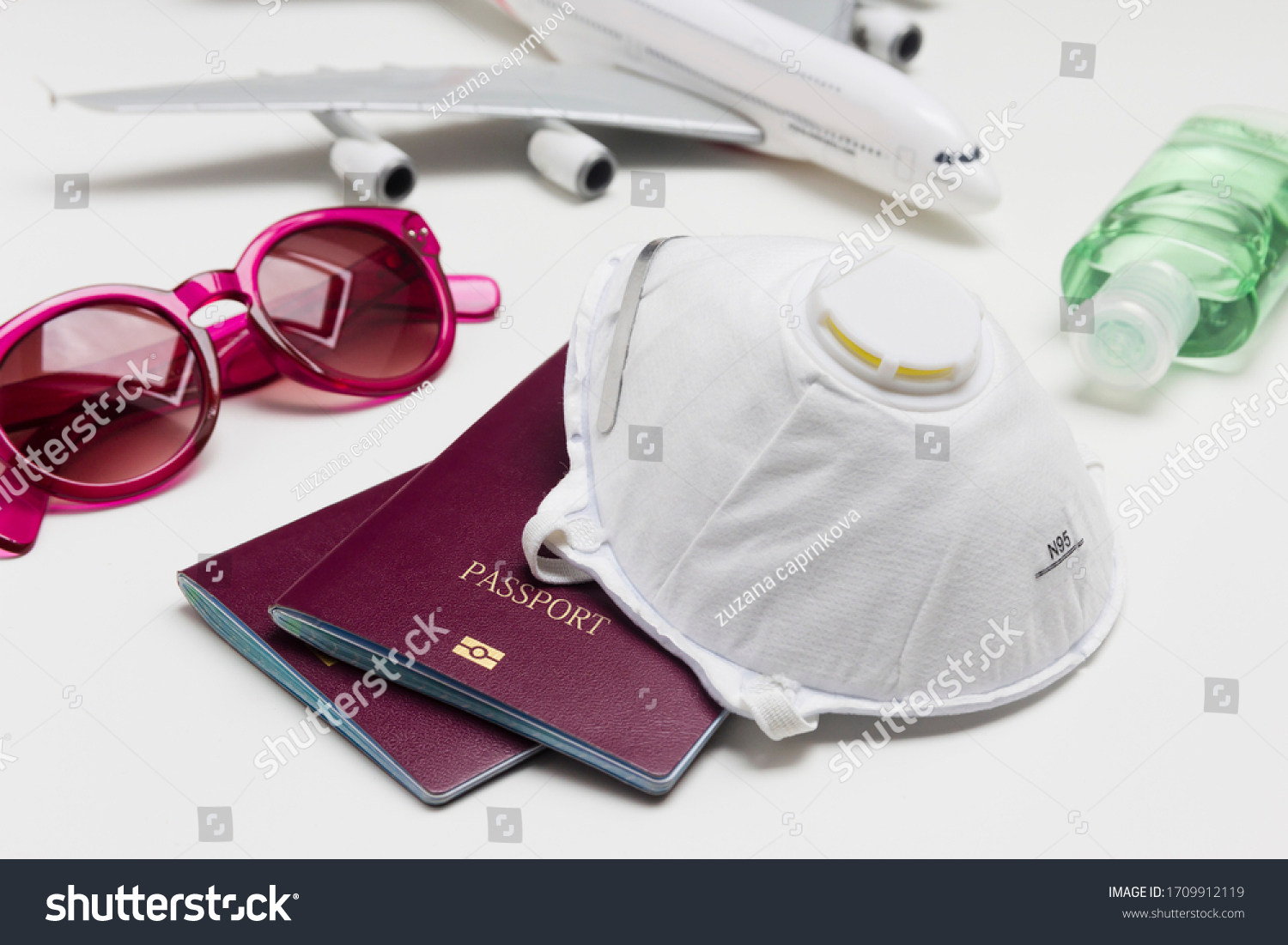 Travelling during the coronavirus outbreak. Passport with face mask, sunglasses and hand sanitizer gel. Travel and Holiday concept corona virus epidemic.  #1709912119