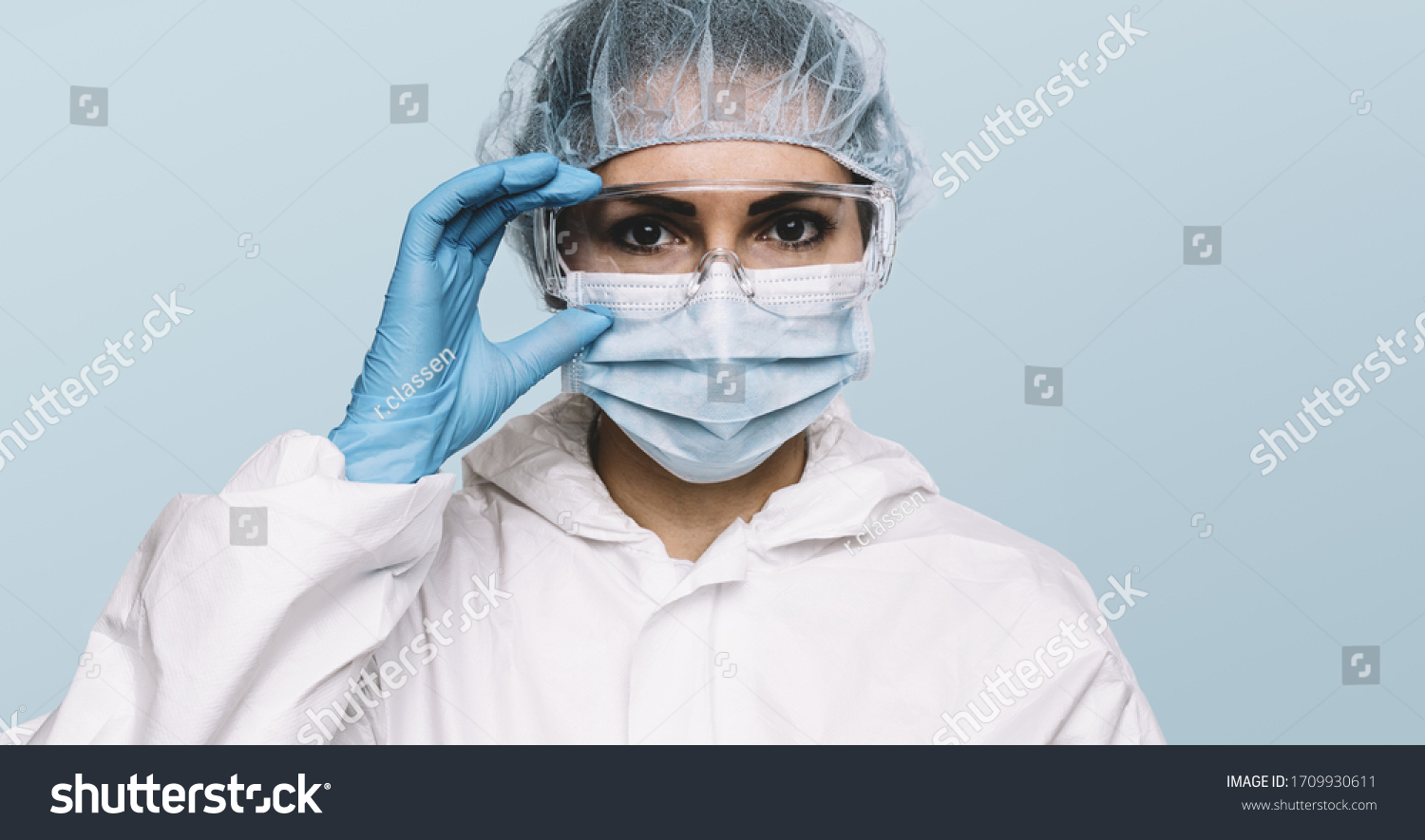 Female Doctor or Nurse Wearing latex protective gloves and medical Protective Mask and glasses on face. Protection for Coronavirus COVID-19 #1709930611