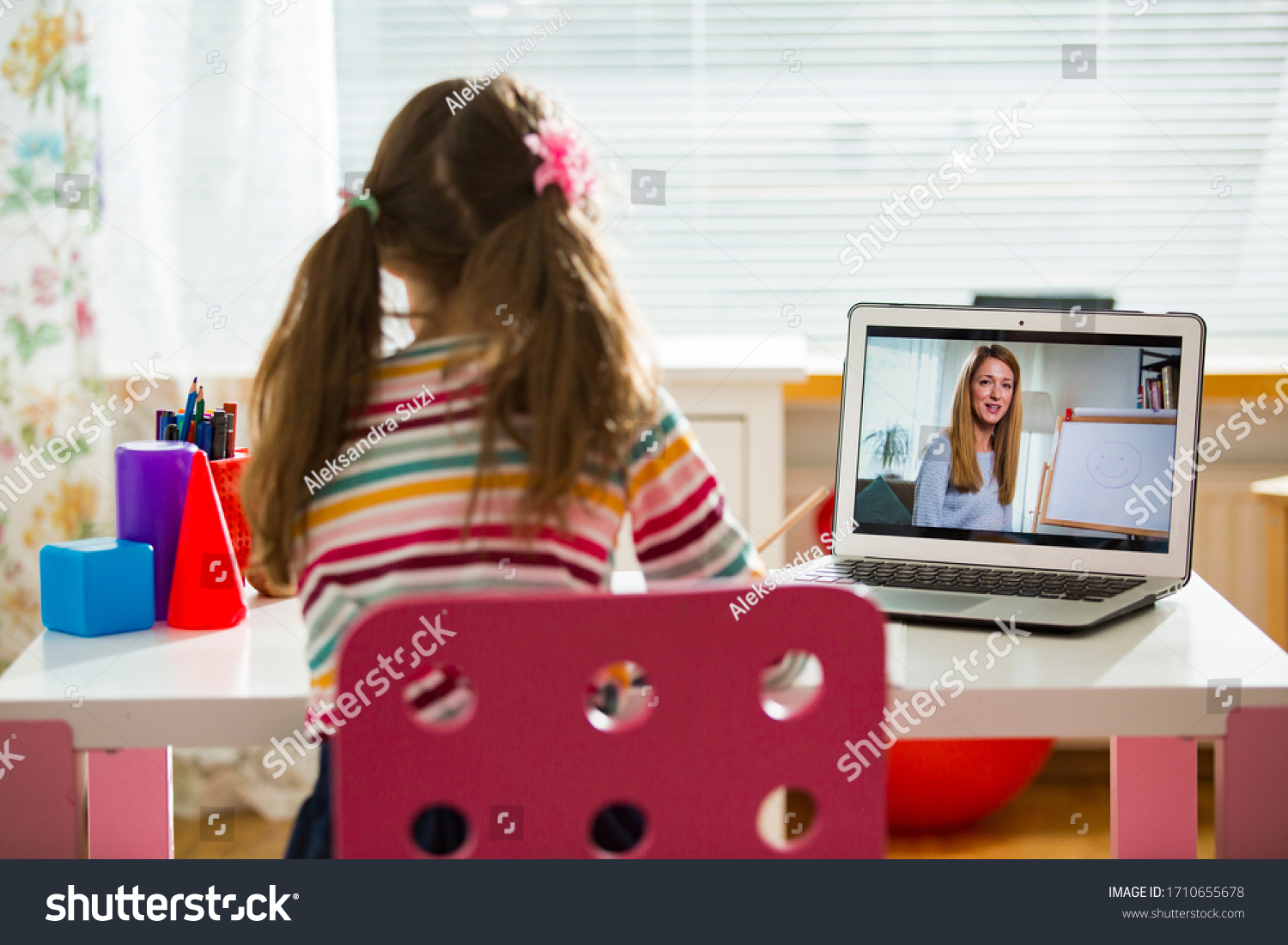 Young female distance teacher having video conference call with pupil using webcam. Online education and e-learning concept. Home quarantine distance learning and working from home. #1710655678