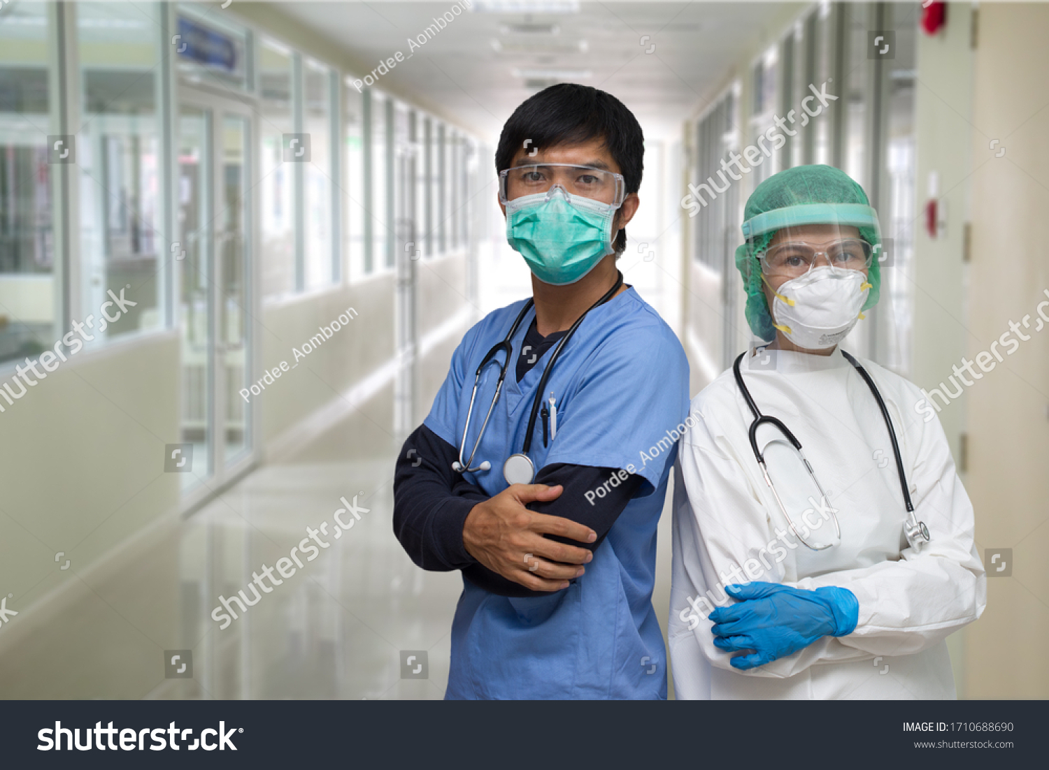 Covid-19  situation: portrait of a Asian young man and woman nurse/ Doctor wearing Personal protective Equipment(PPE) and standing with they arms crossed #1710688690
