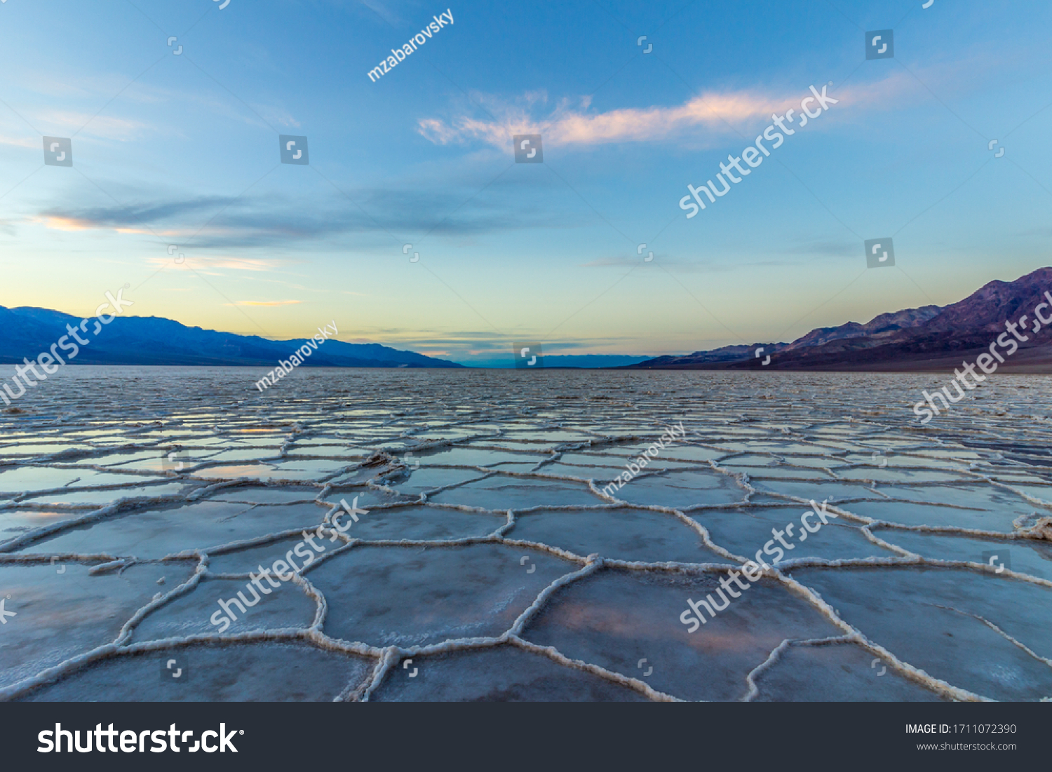Badwater Basin at Sunset. Salt Crust and Clouds Reflection. Death Valley National Park. California, USA #1711072390