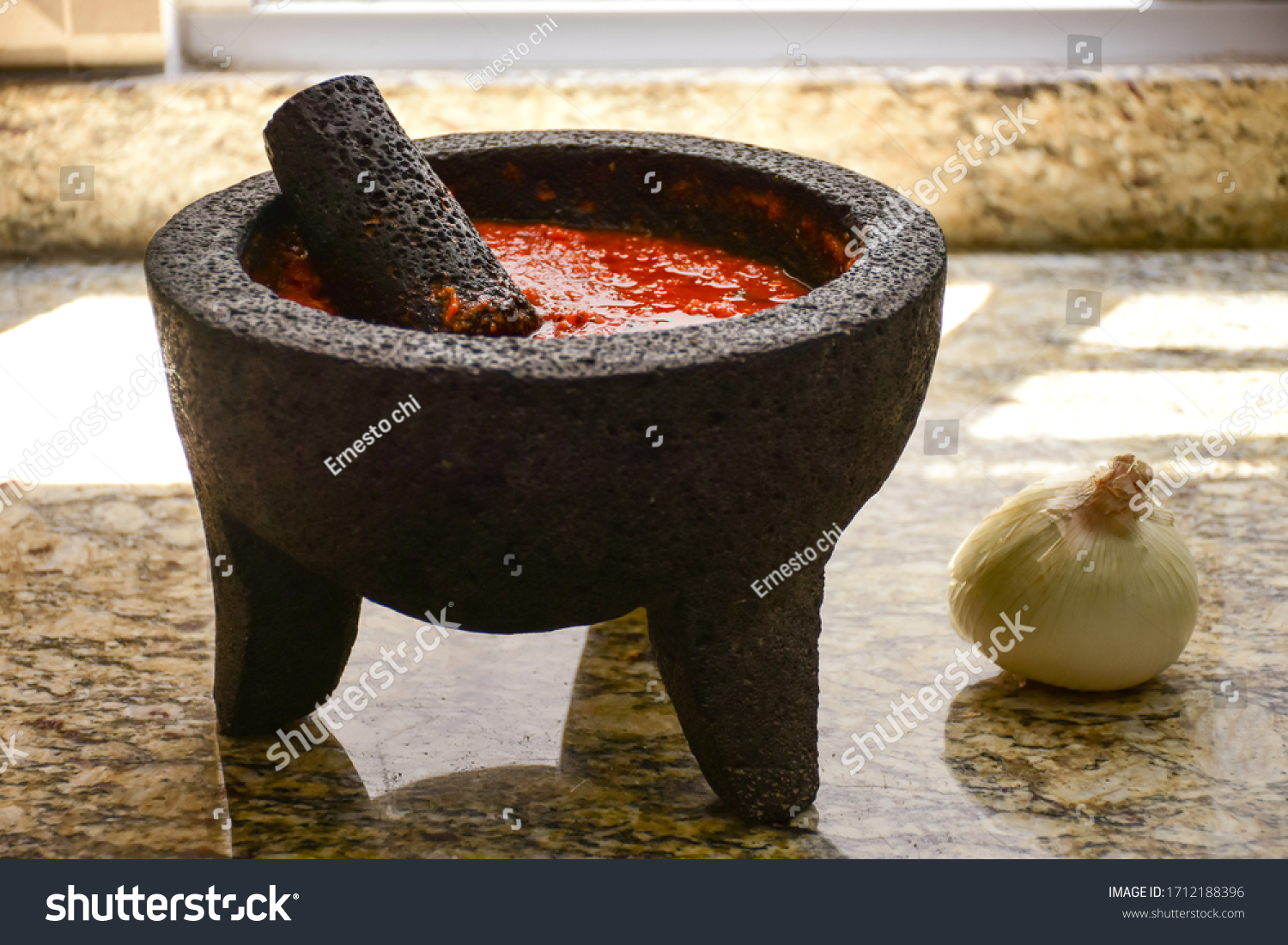 Spicy red sauce made with tomato in a Traditional Mexican molcajete at kitchen #1712188396