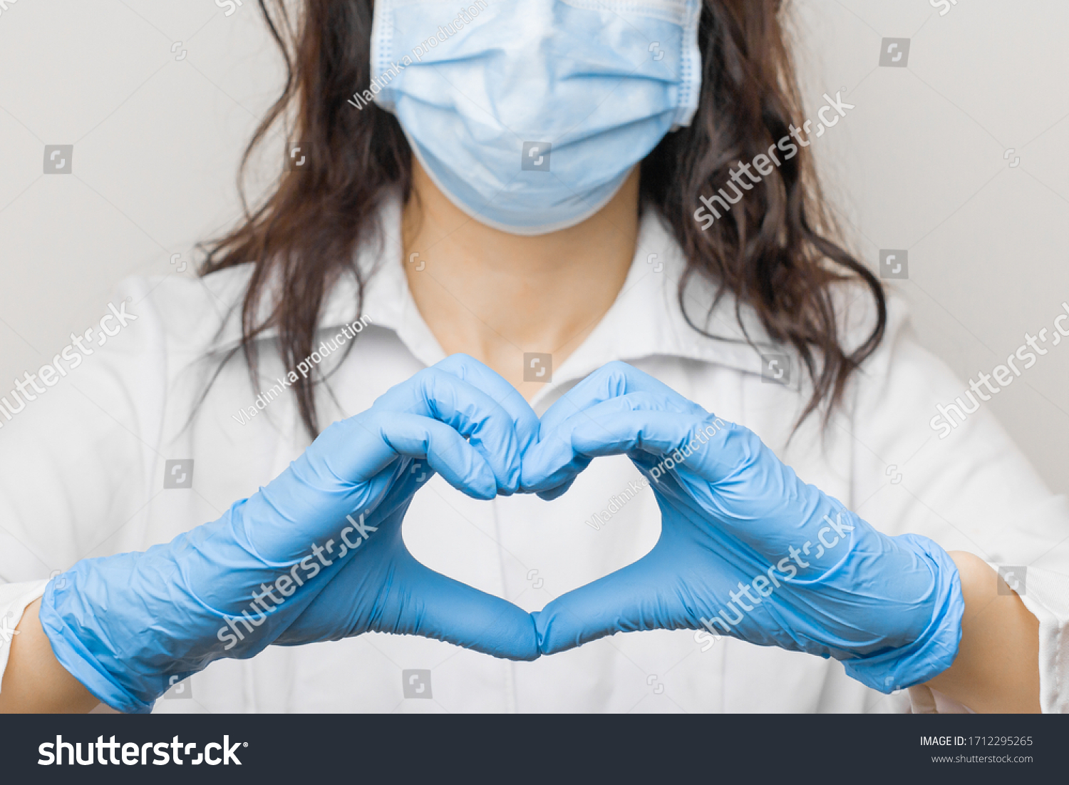 Stop SARSCoV, virus 2020, chinese virus COVID-19. Womens hand in blue medical gloves show heart sign. Concept of protection against HIV. Doctor in blue medical gloves and protective mask. #1712295265