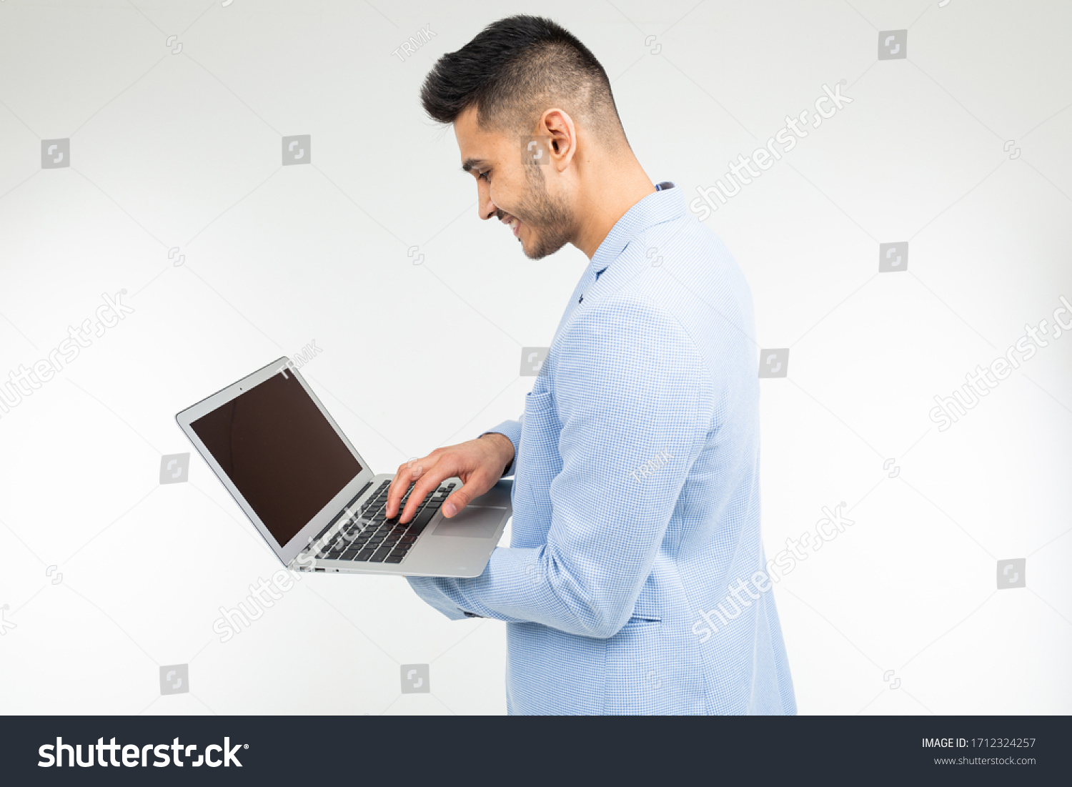 stylish office worker man working on laptop on a white studio background #1712324257