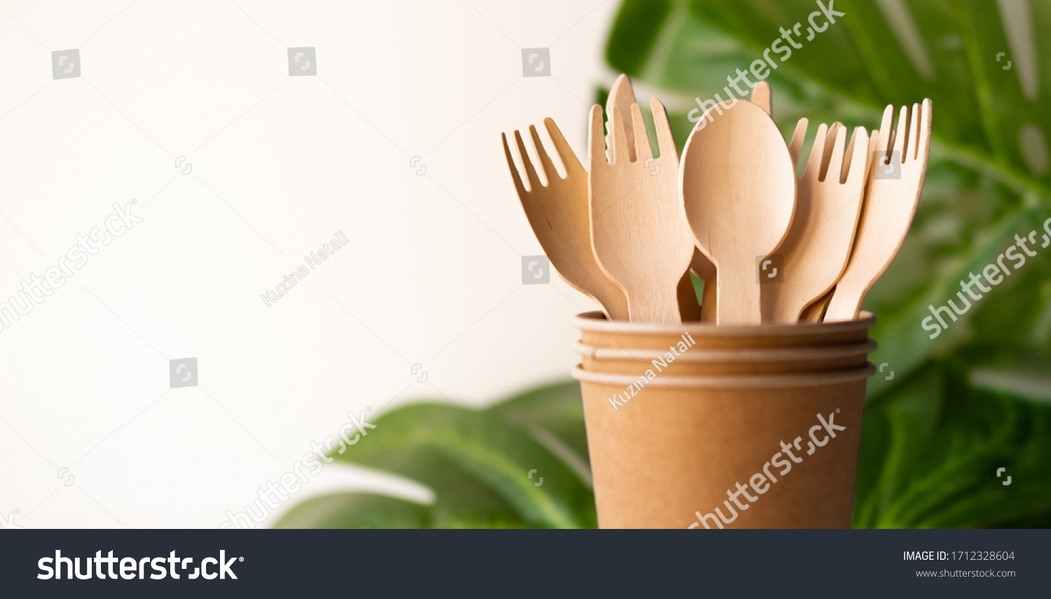 bunner eco friendly disposable kitchenware utensils on white background. wooden forks and spoons in paper cup. and green leaf. ecology, zero waste concept. copyspace. #1712328604