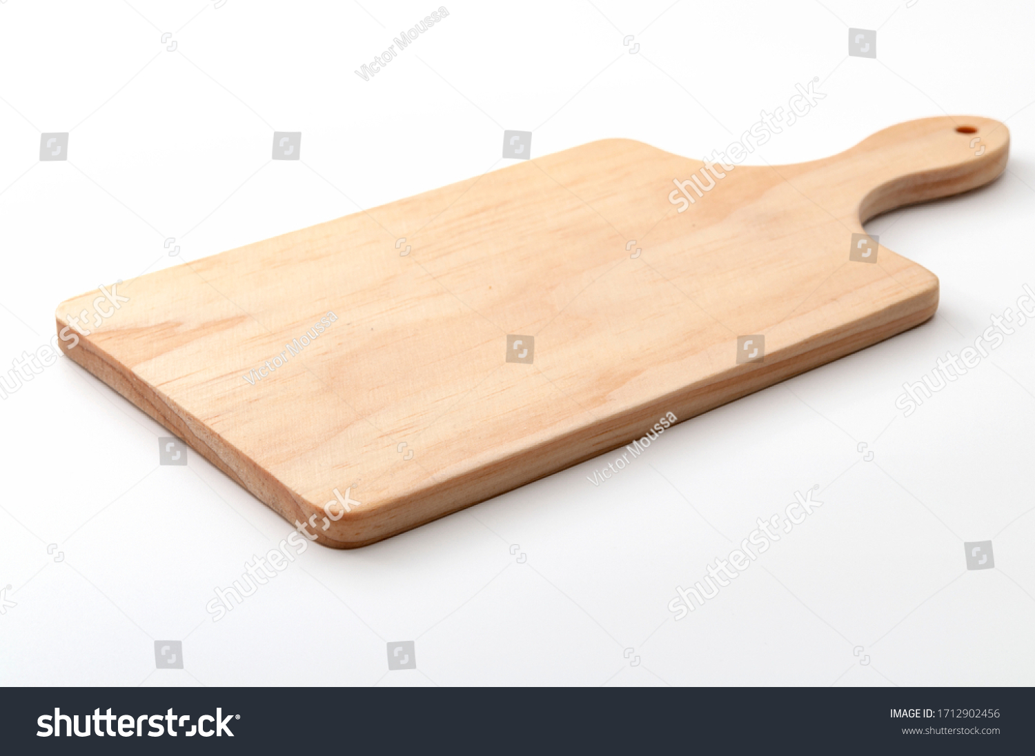 Food preparation tool and kitchen utensils concept with close-up on rectangular wood chopping board with round corners isolated on white background at an angle perspective with clipping path cutout #1712902456