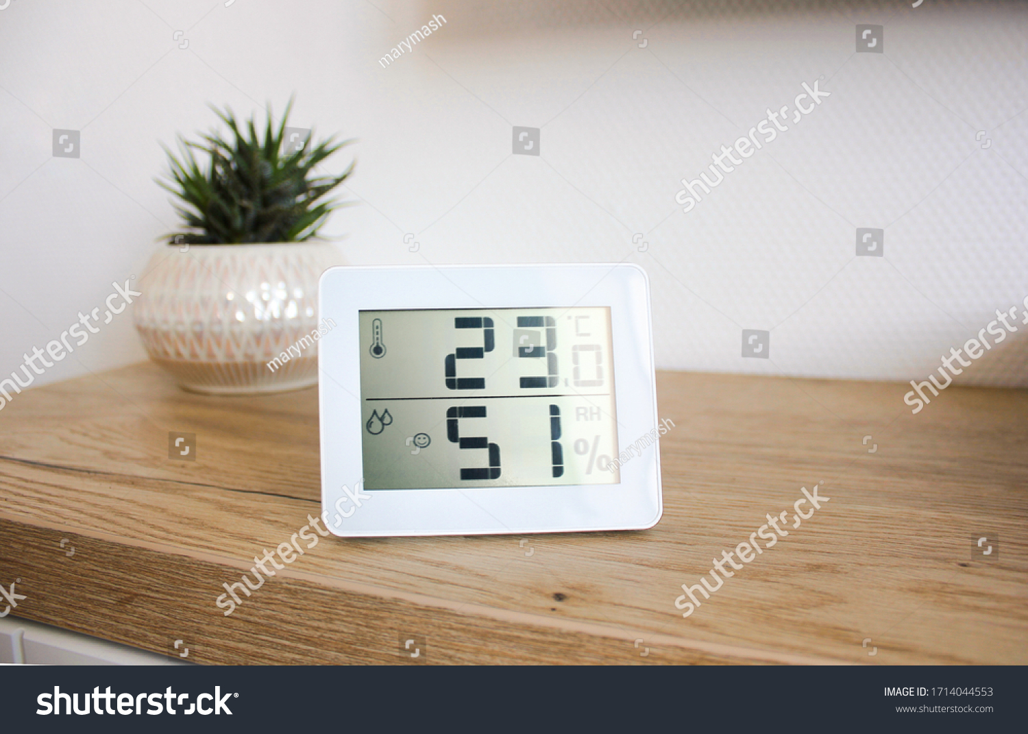 Thermometer hygrometer measuring the optimum temperature and humidity in a house, apartment or office, a photo for articles about the house’s microclimate, health, disease relief and virus treatment #1714044553