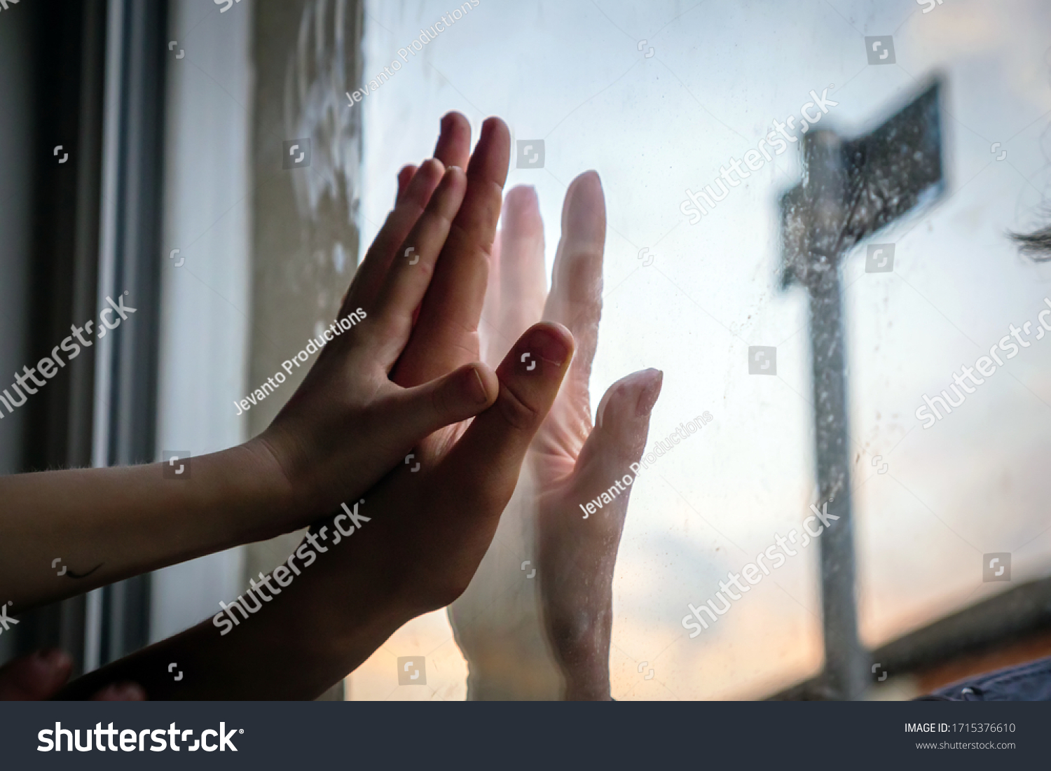 social distancing among the family, hand of the woman and her grandchildren on window plane, concept coronavirus and covid-19 pandemic #1715376610
