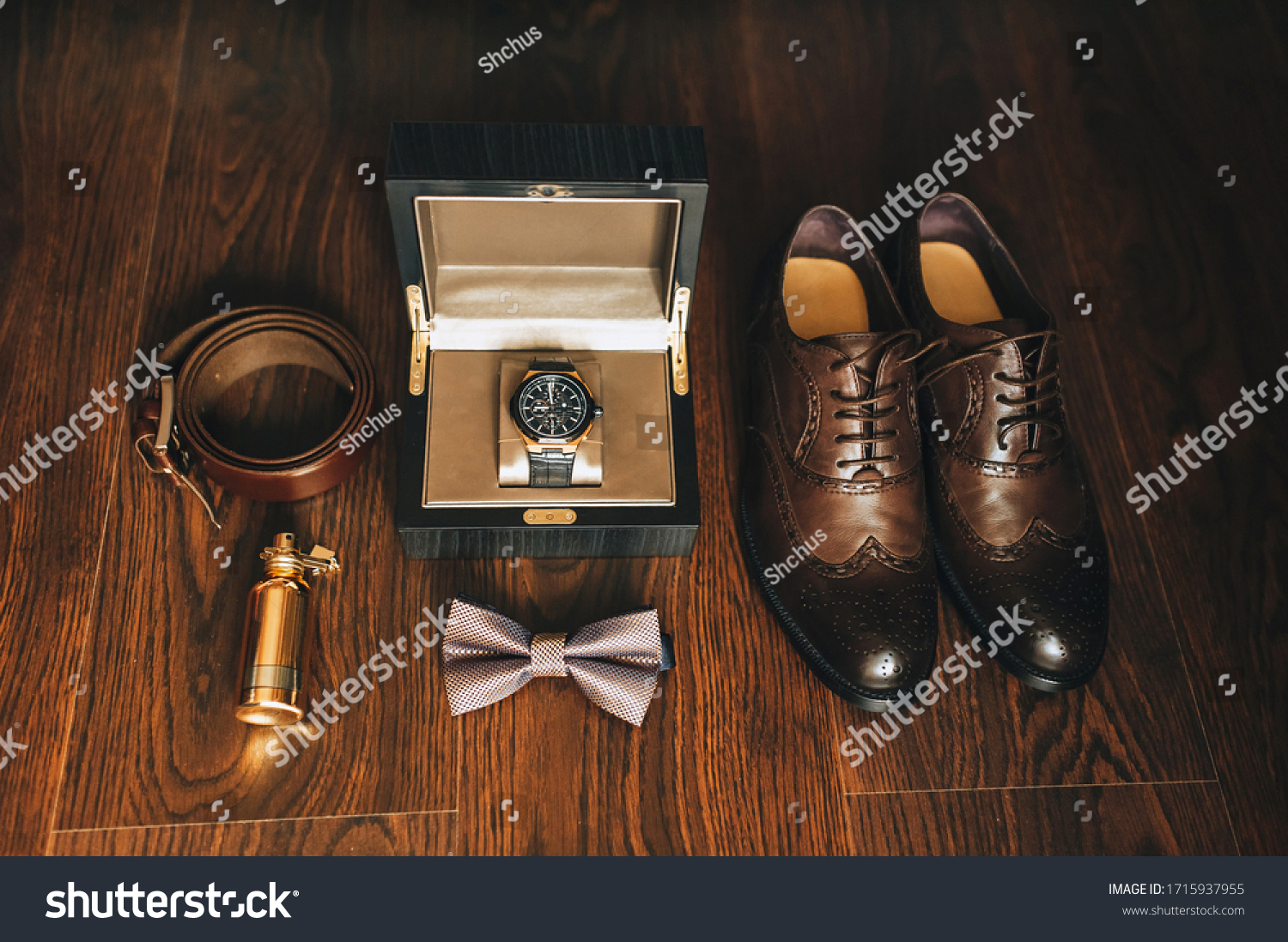 Gentleman's set of businessman and groom: shoes, perfume, belt, watch, bow-tie. Wedding details on a wooden background. Photography, concept. #1715937955