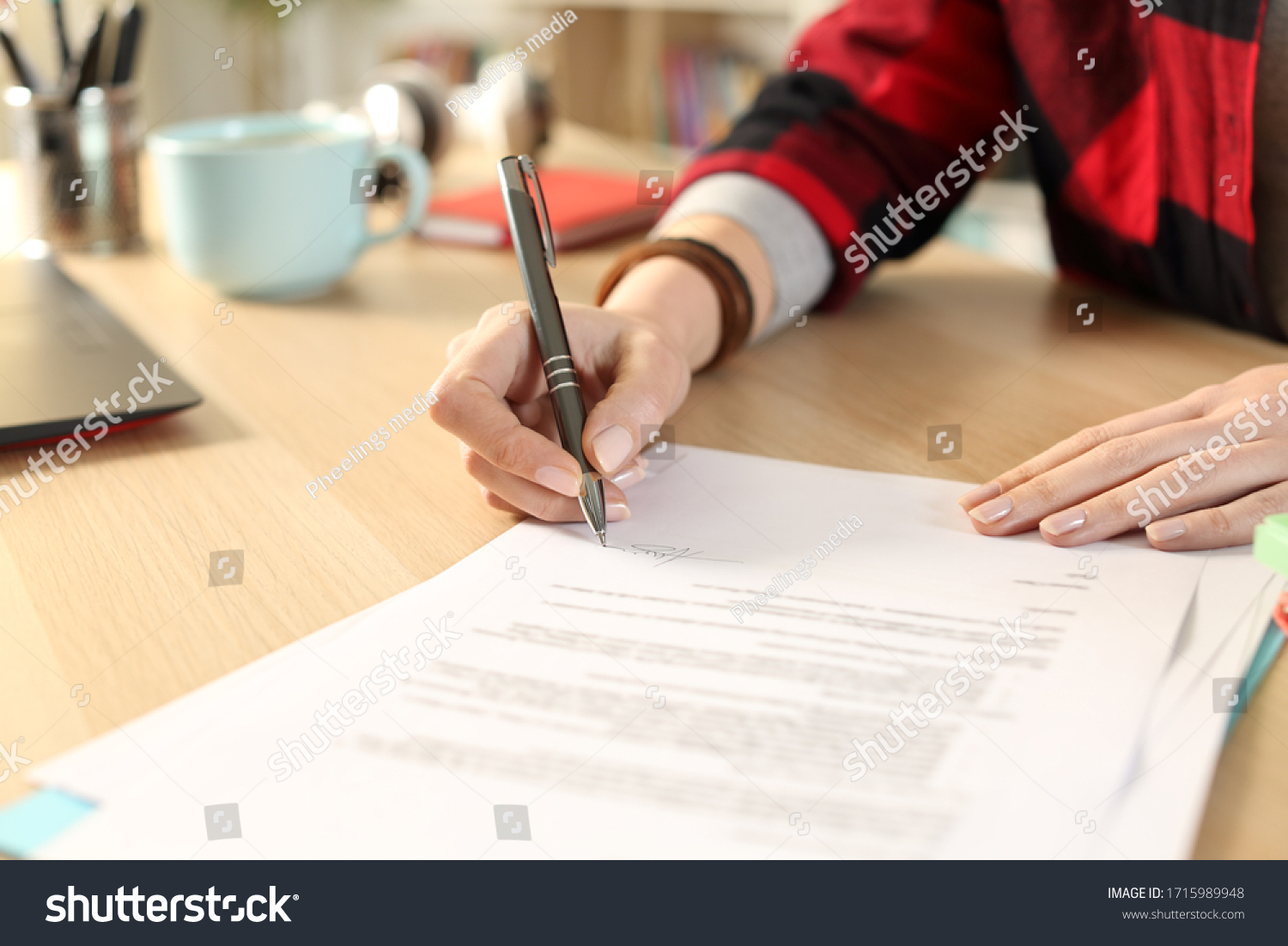 Close up of student girl hands signing contract sitting on a desk at home #1715989948