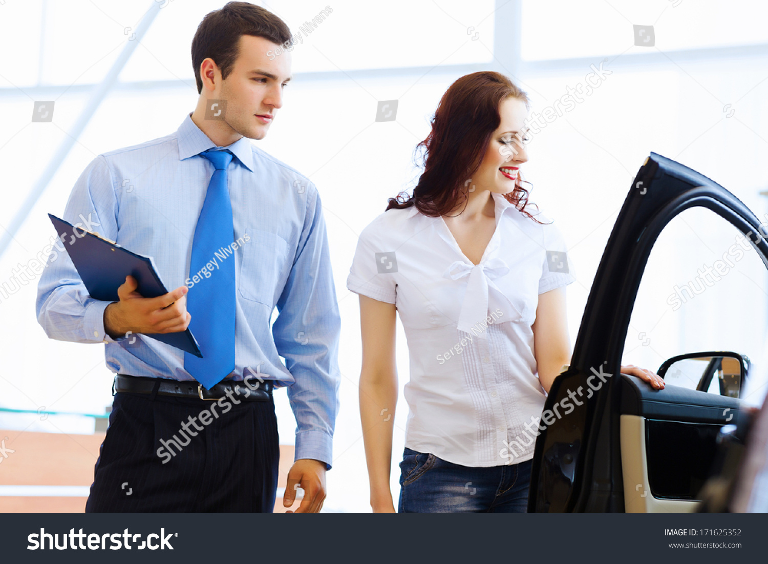 Attractive woman at car salon with consultant choosing a car #171625352
