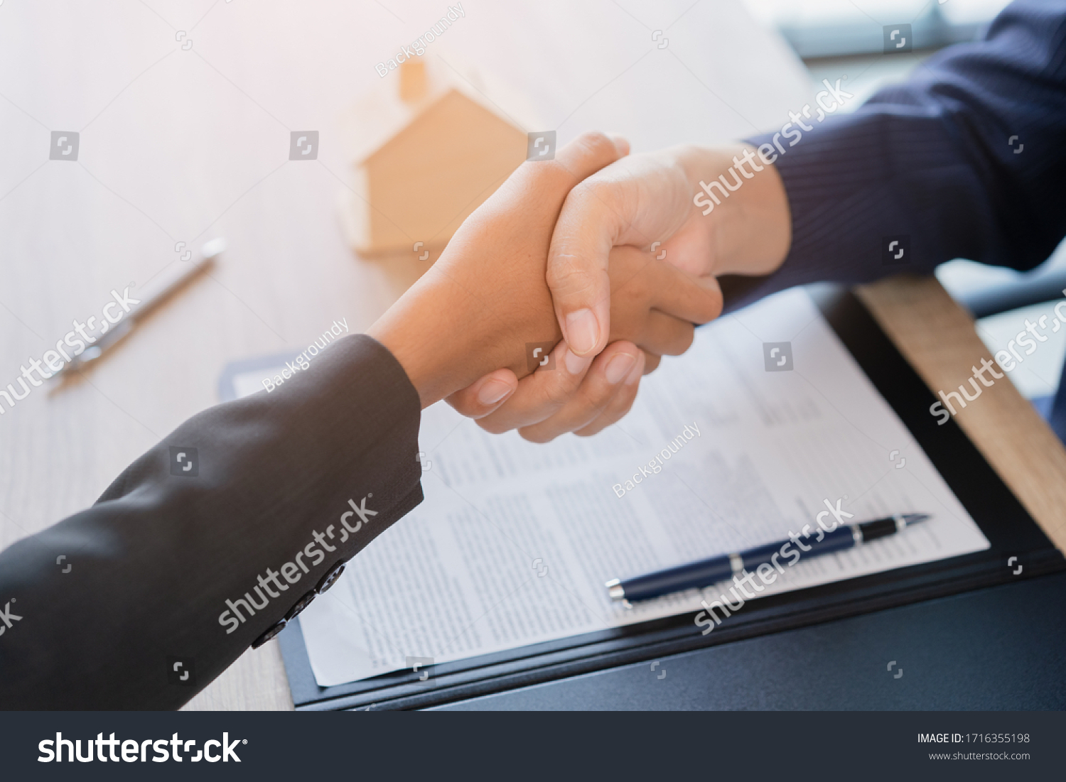 Real estate broker agent Shake hands after customer signing contract document for ownership realty purchase in the office, Business concept and  signing contract

 #1716355198