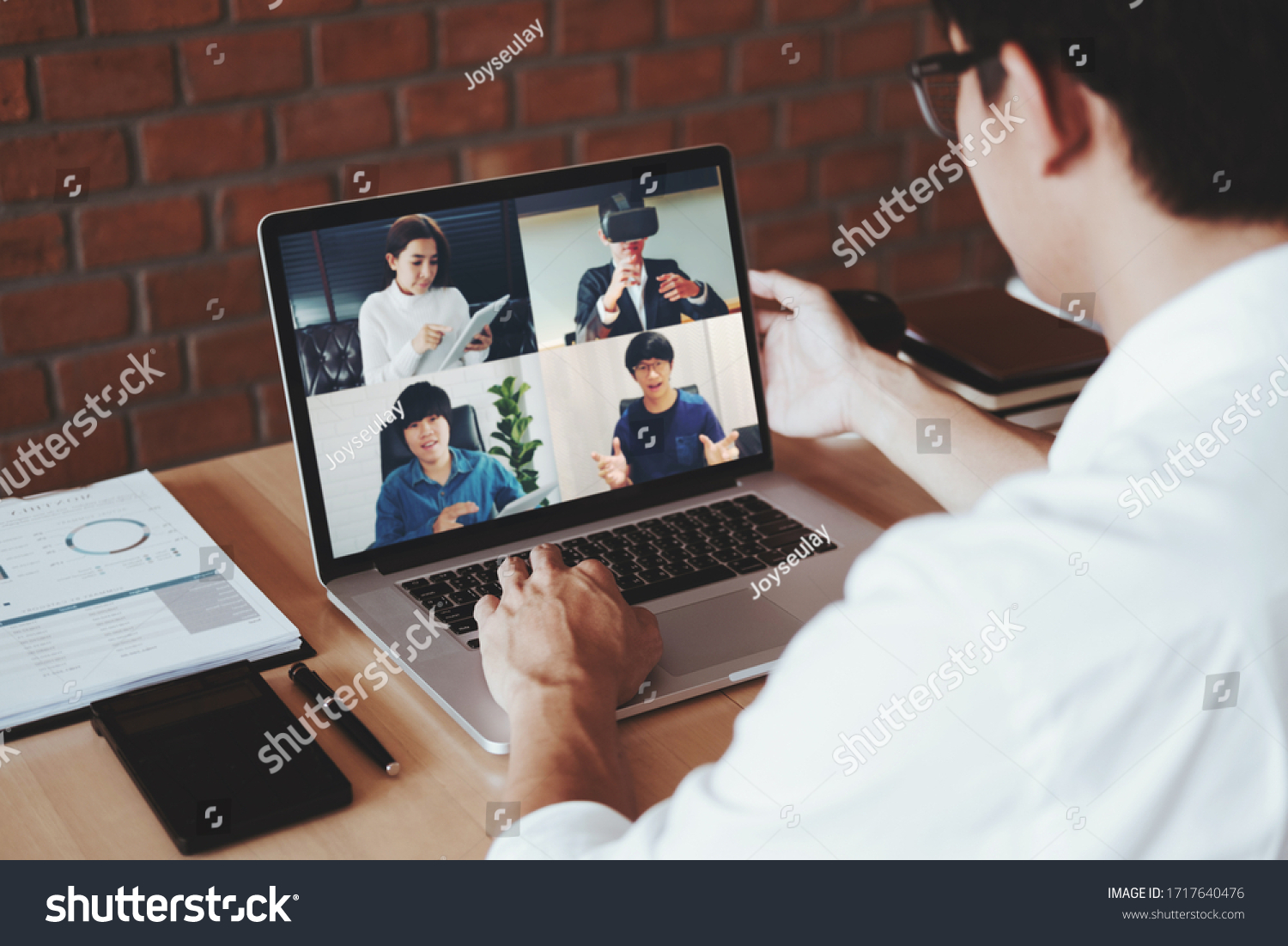 Asian man working from home use Smart working and video conference online meeting with Asian team using laptop and tablet online in video call for new projects #1717640476